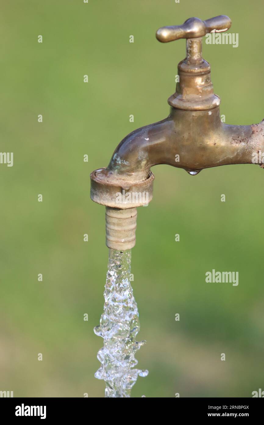 Trinkwasser kommt aus einem Wasserhahn Stockfoto