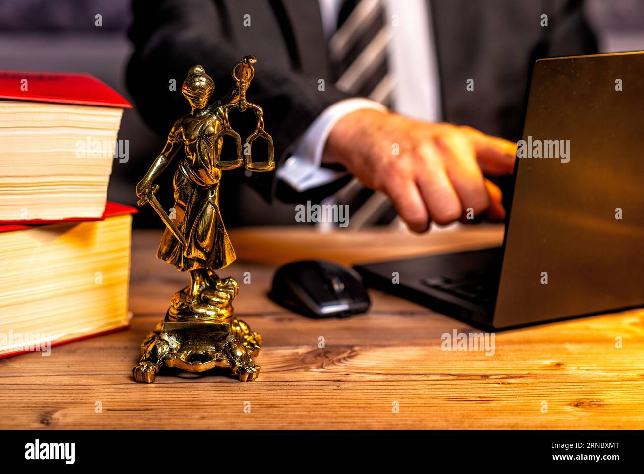 Kanzlei eines Rechtsanwalts mit Büchern und einer Statue von Lady Justice, Göttin Justitia, auf dem Schreibtisch Stockfoto