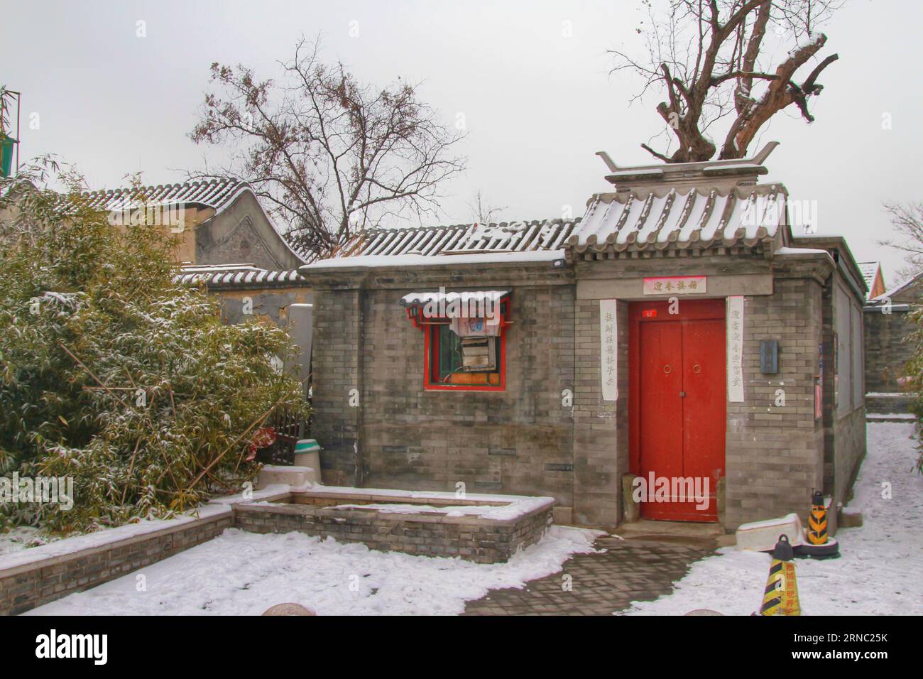 Erleben Sie den faszinierenden Anblick der alten chinesischen Architektur, die in einer unberührten weißen Schneedecke verziert ist, eine zeitlose Mischung aus Geschichte und Winterwunder. Stockfoto