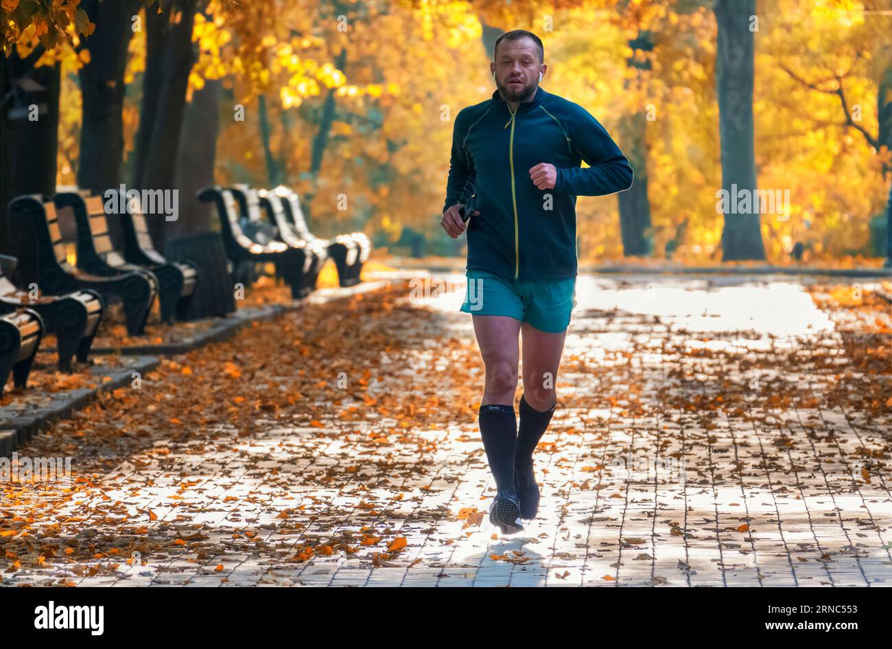 09.10.2022, Kiew, Ukraine. Man geht joggen im wunderschönen Herbststadtpark. Stockfoto