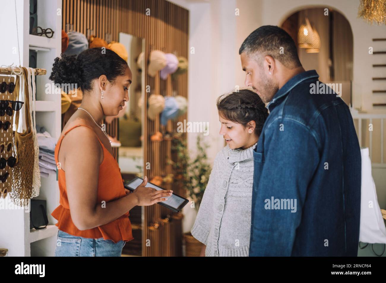 Vertriebsmitarbeiter teilen digitale Tablets mit Kunden in der Modeboutique Stockfoto