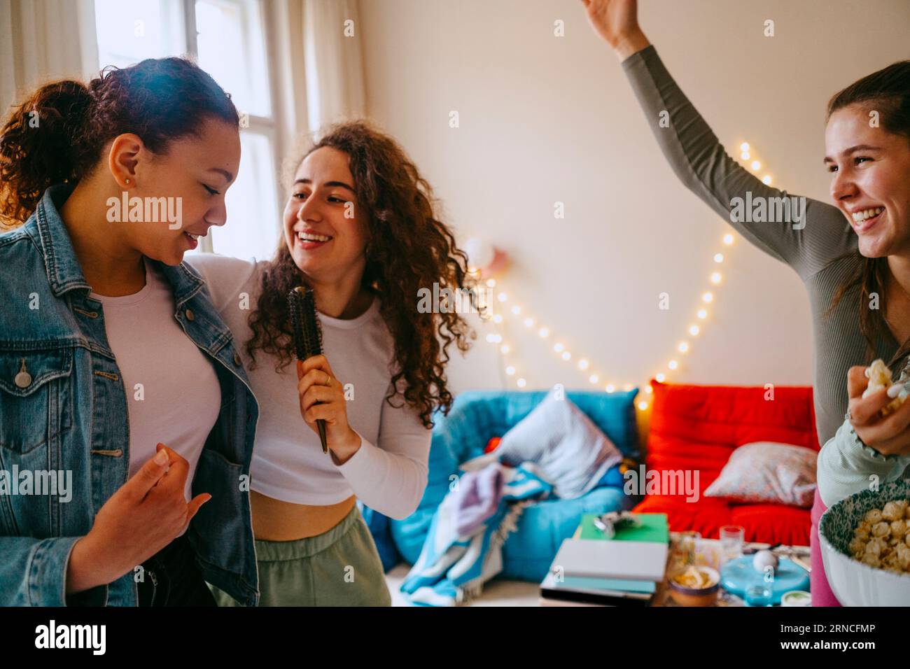 Glückliche Freundinnen, die zu Hause gemeinsam singen Stockfoto