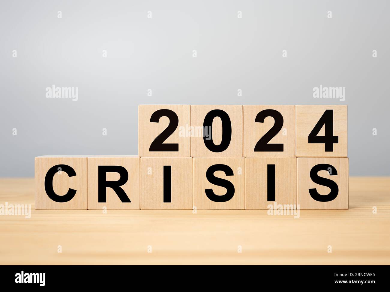 Krisenmanagementkonzept im neuen Jahr 2024 . Unerwartete Situationseffekte für Geschäft und Leben. Holzwürfel 2024 mit TEXTKRISE auf grauem Hintergrund Stockfoto