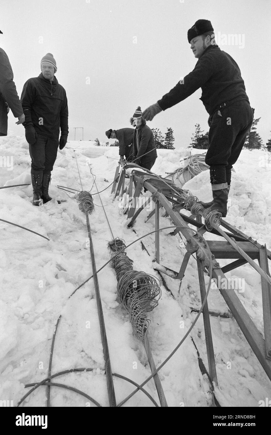 04 - 02 - 1974: Harte Arbeit in der Heide in der Nacht vom 7. Januar haben die Wettergötter Südnorwegen getroffen und das Stromnetz verwüstet. Am schlimmsten getroffen wurde die Brokke-Linie in den Mooren östlich von Byglandsfjord. Hier wird gespeichert, was gespeichert werden kann. Heute transportiert ein Hubschrauber Stöcke und anderes Material in den Berg. Die Arbeit wird sechs Wochen dauern. Die Typen auf dem Bild räumen die "Wracks" weg, um Platz für neue Pole zu schaffen. Foto: Sverre A. Børretzen / aktuell / NTB ***FOTO NICHT VERARBEITET*** dieser Text wurde automatisch übersetzt! Stockfoto