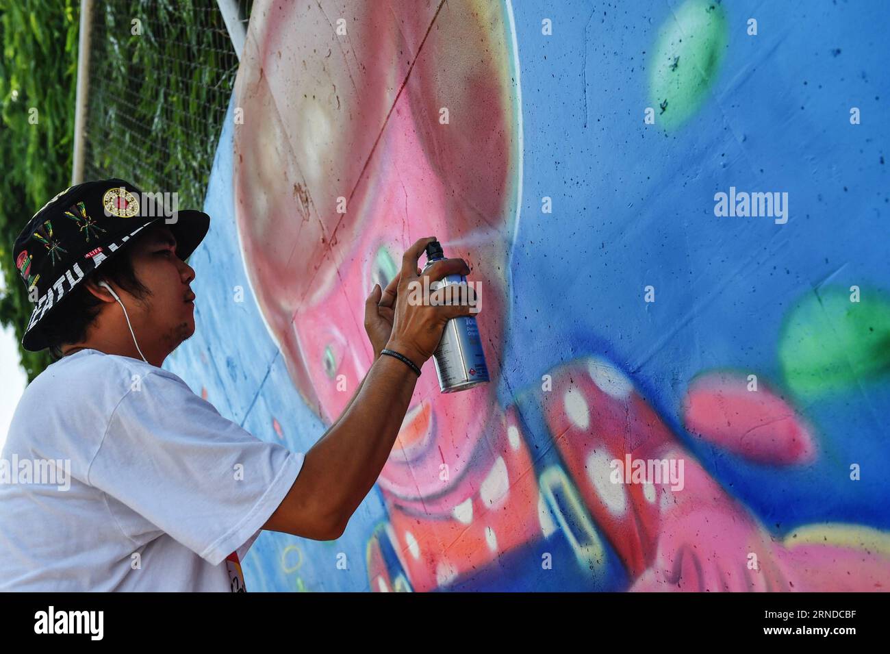 (160515) -- NAKHON SAWAN, 15. Mai 2016 -- Ein Straßenkünstler spritzt am 15. Mai 2016 Farbe auf seine Graffiti-Arbeit außerhalb einer lokalen Abwasserbehandlungsanlage in der Stadt Nakhon Sawan in Zentralthailand. Mehr als sechzig Straßenkünstler aus ganz Thailand wurden vom 13. Bis 15. Mai von der Stadtverwaltung zum Nakhon Sawan Street Art Project eingeladen. Innerhalb von drei Tagen ist es den Künstlern gelungen, die leeren Außenwände einer lokalen Abwasserbehandlungsanlage in eine Graffiti-Galerie zu verwandeln, die sich über etwa vierhundert Meter erstreckt.) THAILAND-NAKHON SAWAN-POP KULTUR-STREET ART-GRAFFITI Stockfoto