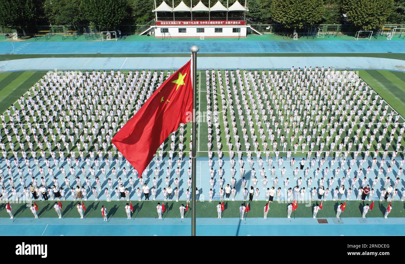 HUAI'AN, CHINA - 1. SEPTEMBER 2023 - Grundschullehrer und -Schüler nehmen an der nationalen Flaggenhetzungszeremonie für das neue Semester in Huai'an c Teil Stockfoto
