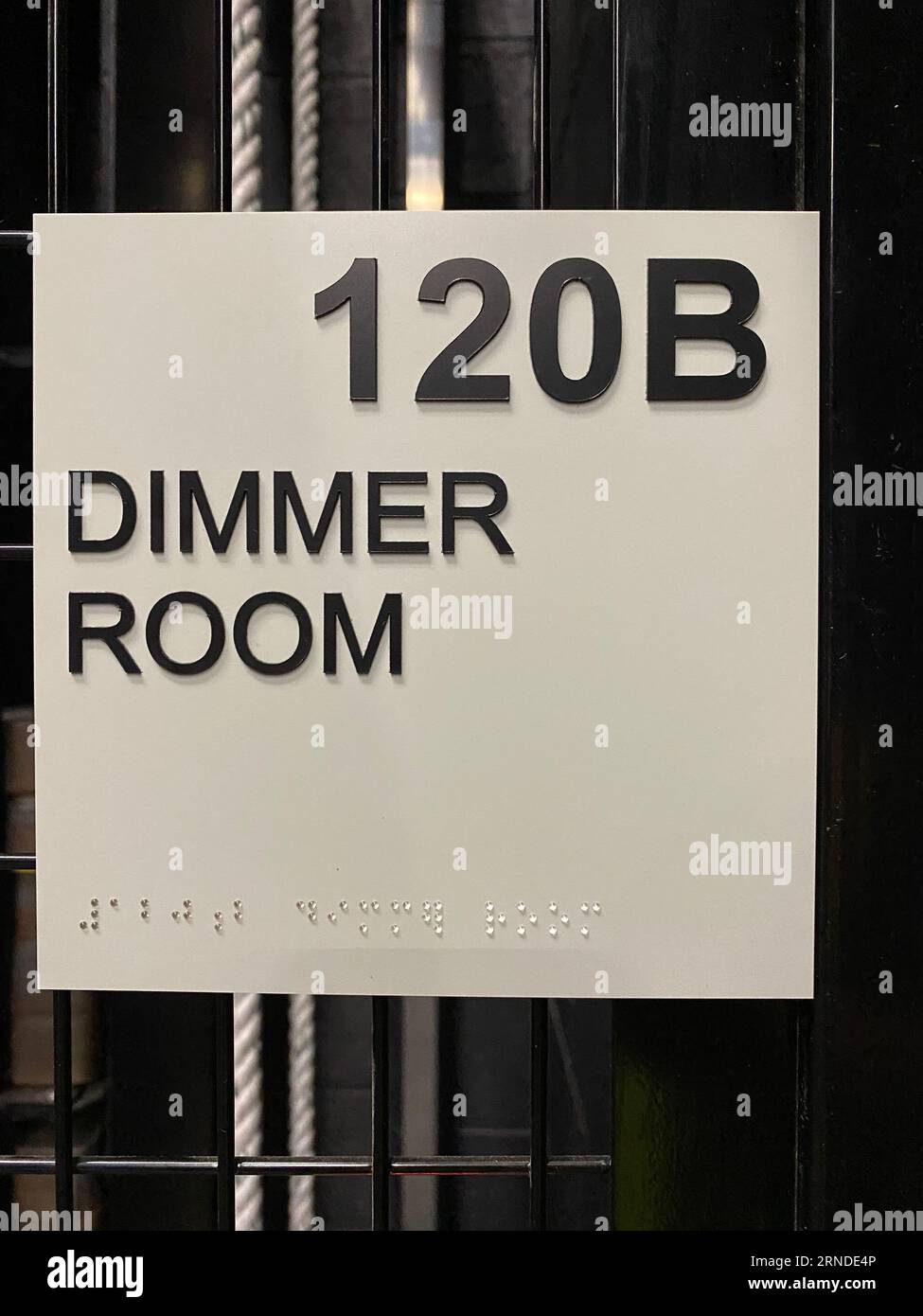 Dimmer Room-Schild mit brailleschrift, an einer Tür innerhalb eines Theaters. Stockfoto