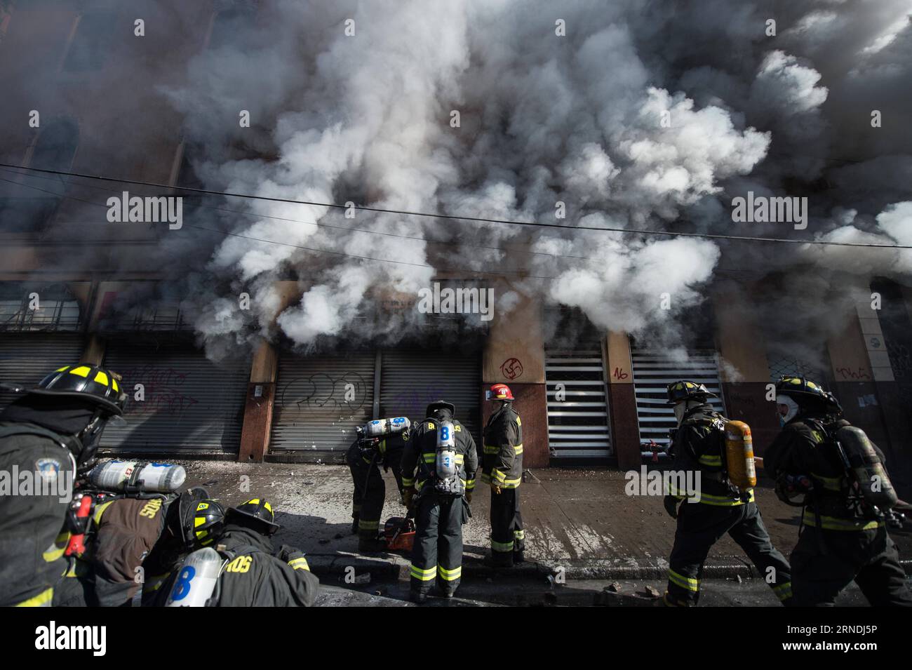 (160521) -- VALPARAISO, 21. Mai 2016 -- Feuerwehrleute versuchen, ein Feuer während eines marsches zu löschen, der vom Konföderat chilenischer Studenten (CONFECH) in Santiago, der Hauptstadt Chiles, am 21. Mai 2016 ausgerufen wurde. Die Demonstranten treffen auf die Polizei der Unruhen in der Umgebung des Kongresses in Valparaiso, Chile, während die chilenische Präsidentin Michelle Bachelet ihre jährliche Botschaft an die Nation überbringt. Der massive marsch von Studenten, Arbeitern und verschiedenen sozialen Organisationen im Land endete mit gewalttätigen Vorfällen, so die lokale Presse. Jorge Villegas) (jg) CHILE-SANTIAGO-PROTEST e JORGExVILLEGAS PUBLICATIONxN Stockfoto