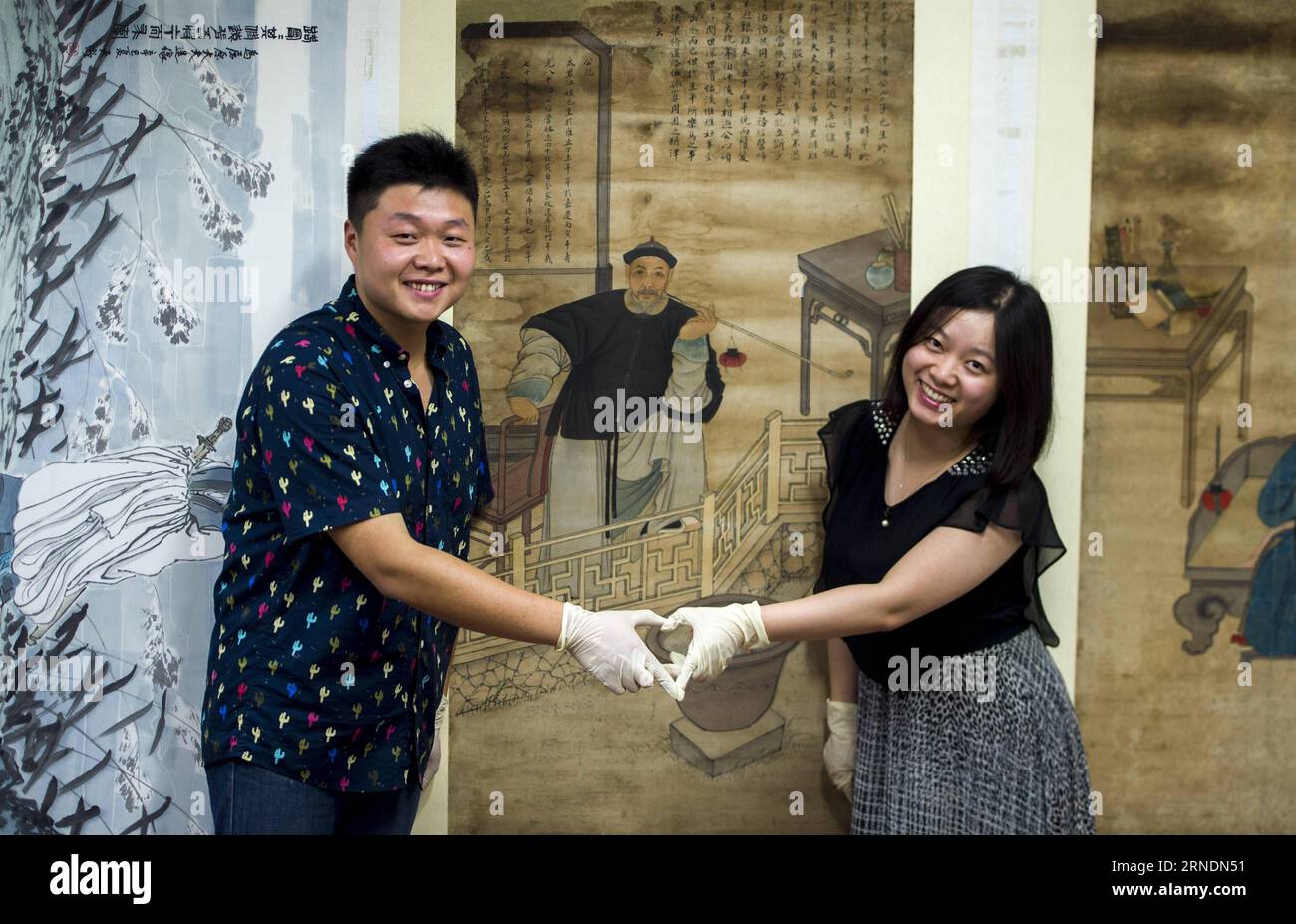 Zhao Xiaolong (L) und seine Frau Zhang Xiaolong posieren für Fotos im Hubei Museum in Wuhan, Hauptstadt der zentralchinesischen Provinz Hubei, 16. Mai 2016. Zhang Xiaolong und Zhao Xiaolong, ein Paar, das in den 1980er Jahren geboren wurde, arbeiten beide an der Restaurierung kultureller Reliquien im Hubei Museum. Zhao und Zhang haben sich im gleichen Alter auf verschiedene berufliche Aspekte spezialisiert: Zhao widmet sich der Restaurierung kultureller Reliquien und Zhang ist gut in der Materialerkennung. Sie bauen ihre Beziehung durch Zusammenarbeit auf und tragen ihre Leidenschaft zur Kulturgeschichte bei.) (Zwx) Stockfoto