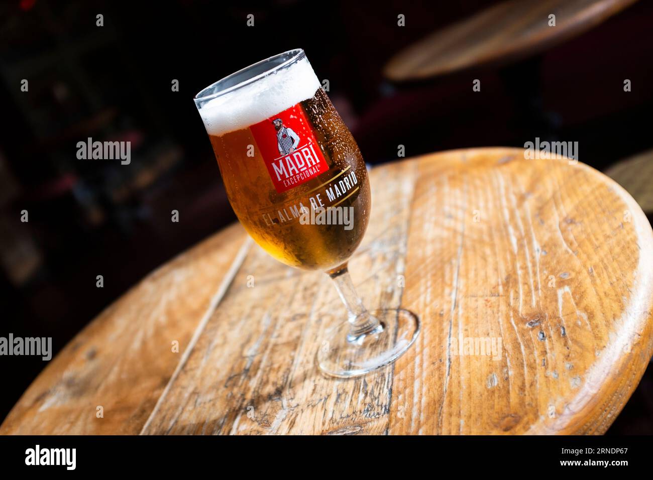 Bier aus kaltem Madrí-Lagerbier, das auf einem Holztisch steht Stockfoto
