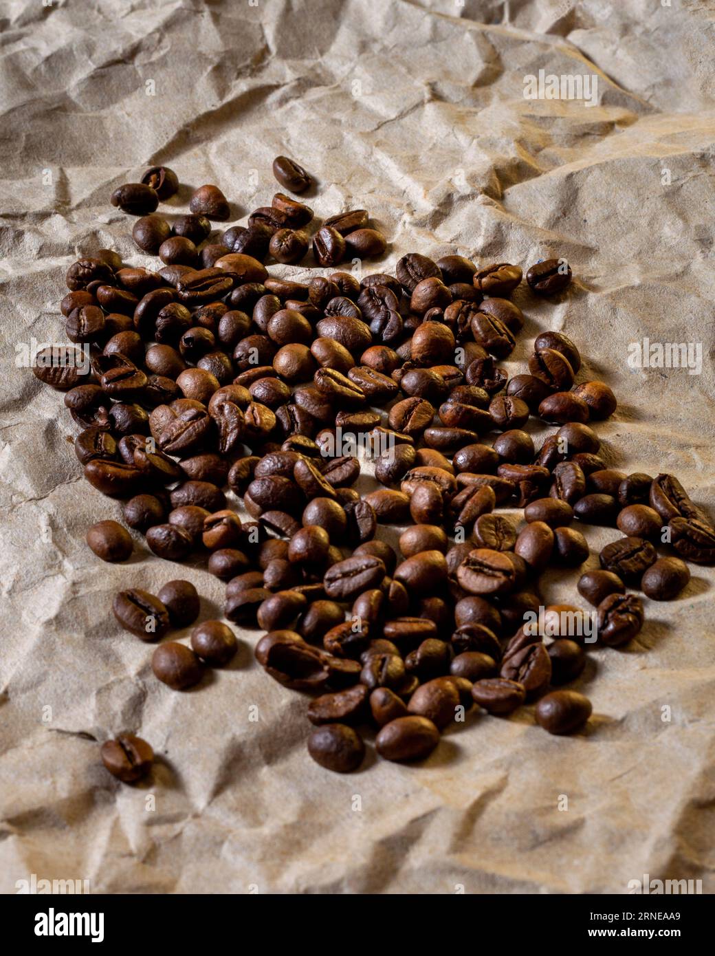 Geröstete Kaffeebohnen in einem Stapel auf einem Papierhintergrund Stockfoto