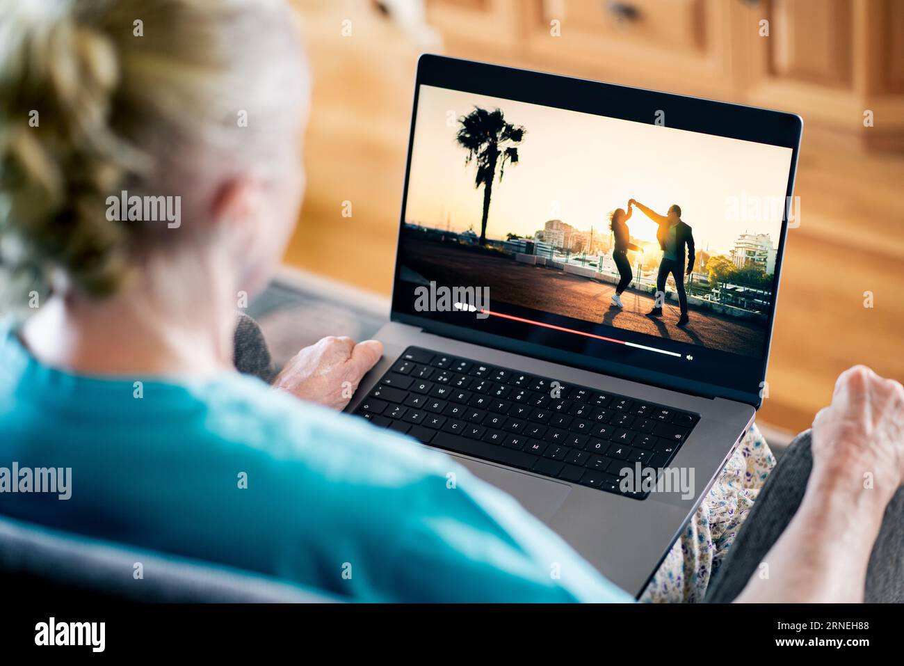 Alte Seniorin, die sich Filme mit Laptop ansieht, während der Stream-Service läuft. TV- oder Serien-On-Demand-Website. Stockfoto