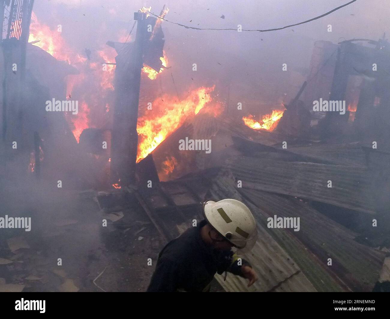 (160628) -- QUEZON CITY, 28. Juni 2016 -- Ein Feuerwehrmann deckt sein Gesicht bei einem Feuerfall in einem Slum-Gebiet, Quezon City, Philippinen, 28. Juni 2016. Laut dem philippinischen Bureau of Fire (BFP) wurden mehr als 300 Shanties im Feuer zerstört und 600 Familien obdachlos gemacht. PHILIPPINEN-QUEZON CITY-SLUM AREA-FIRE RouellexUmali PUBLICATIONxNOTxINxCHN 160628 Quezon City Juni 28 2016 ein Feuerwehrmann deckt sein Gesicht BEI einer Brandszene in einem Slum Area Quezon City die Philippinen Juni 28 2016 mehr als 300 Shanties wurden im Feuer zerstört und ließen 600 Familien zu Hause O Stockfoto