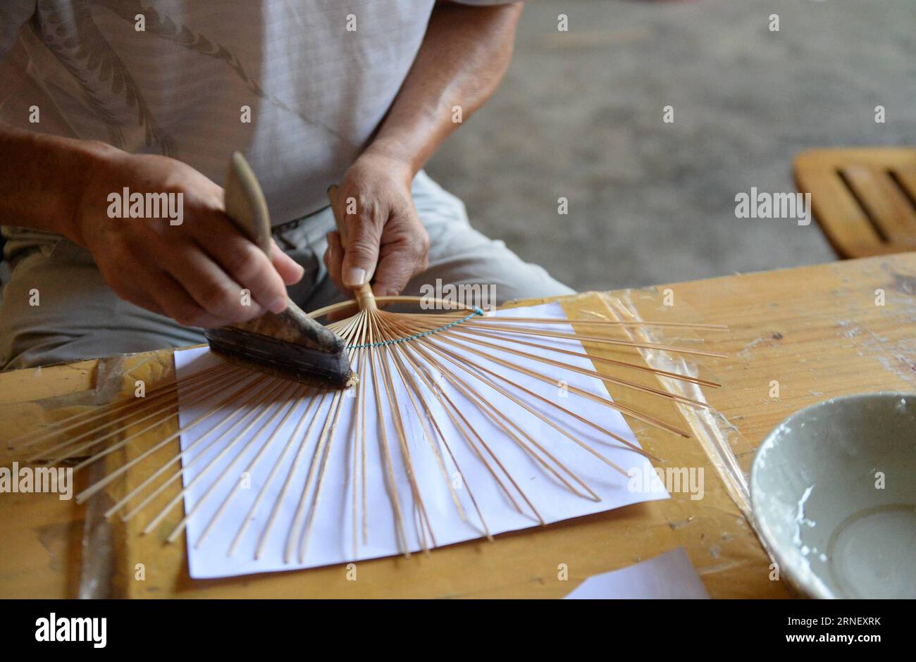 Der Volkskünstler Huang Shuofu macht die Rippen eines mondförmigen Ventilators im Linchuan County, der südchinesischen autonomen Region Guangxi Zhuang, am 6. Juli 2016. Linchuan County ist ein berühmter Produktionsstandort in Guangxi für chinesische traditionelle Mondfässer oder runde Fässer. ) (wyo) CHINA-GUANGXI-FOLK ART-MOON-SHAPED FAN (CN) RenxPengfei PUBLICATIONxNOTxINxCHN Folk Artist Huang macht die Rippen eines Mond geformten Supporters in Linchuan County Südchina S Guangxi Zhuang Autonomous Region 6. Juli 2016 Linchuan County IST eine berühmte Produktionsbasis in Guangxi für chinesische traditionelle oder runde Mond Unterstützer unterstützt Stockfoto