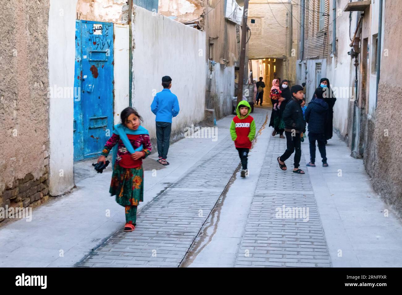 Shiraz, Iran – 31. Dezember 2022: Eine junge iranische Frau im Kopftuch und ihr Sohn und ihre Tochter spielen draußen Stockfoto