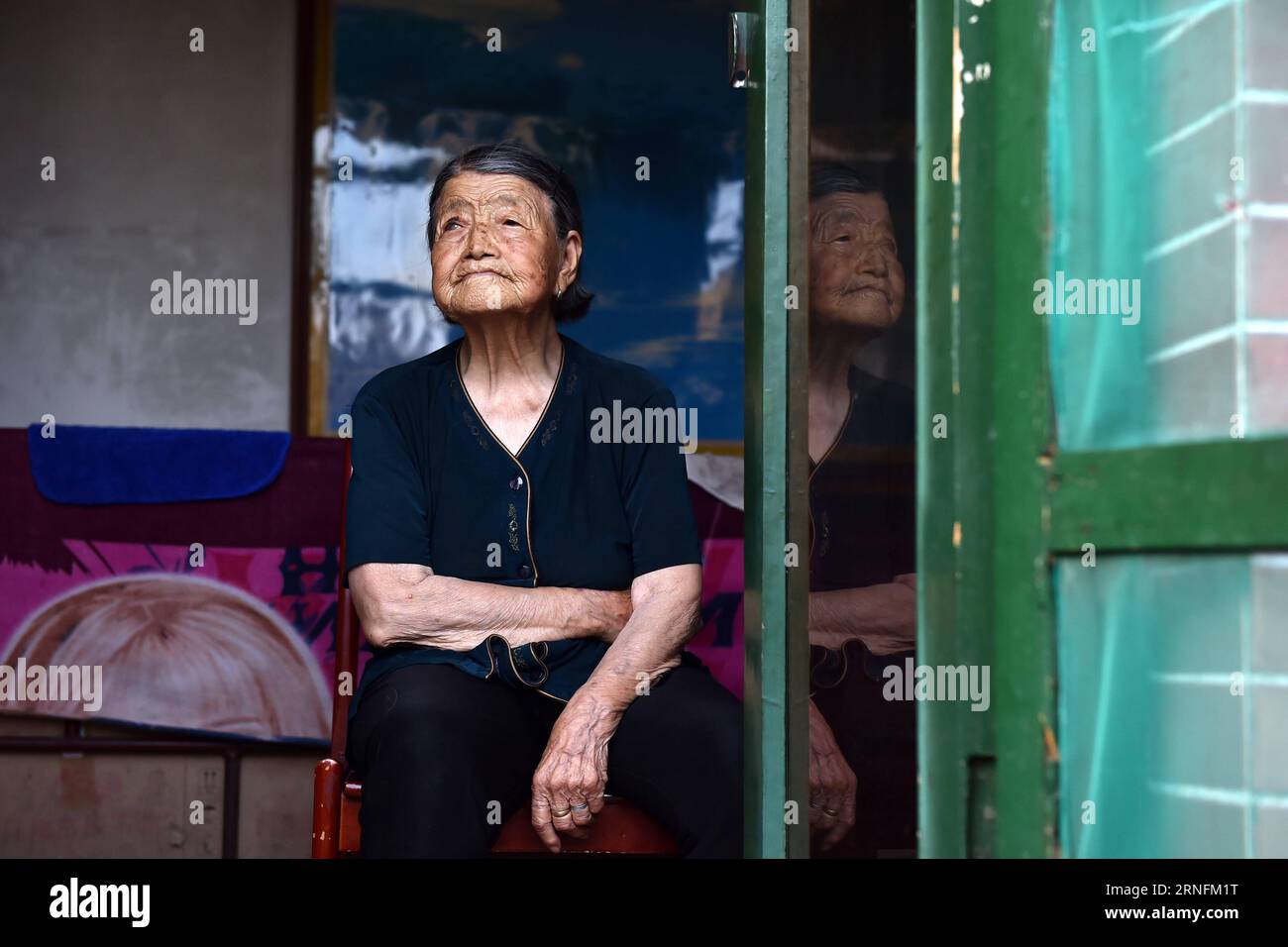 (160815) -- TAIYUAN, 15. August 2016 -- Hao Yuelian, eine 88-jährige Frau, die während des Zweiten Weltkriegs als Trostfrau dienen musste, sitzt am Fenster in ihrem Haus im Dorf Yanggongling im Wuxiang County, Provinz Shanxi in Nordchina, 2. August 2016. Am Montag jährte sich die bedingungslose Kapitulation Japans am Ende des Zweiten Weltkriegs zum 71. Mal Etwa 400.000 Frauen in Asien wurden während des Zweiten Weltkriegs zu Trostfrauen für die japanische Armee gemacht, von denen fast die Hälfte Chinesen sind, laut einem Forschungszentrum für Trostfrauen unter dem Humanities and Communication College of Shanghai Normal U Stockfoto