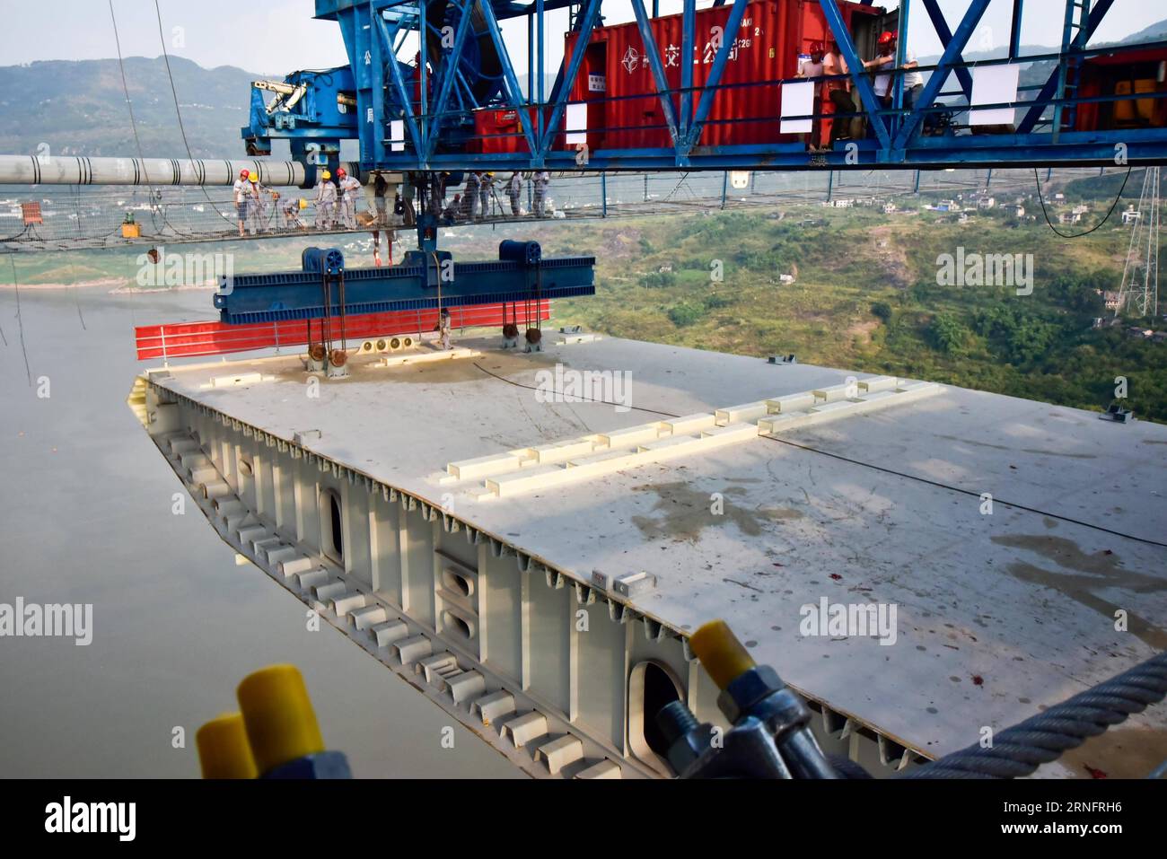 (160822) -- CHONGQING, 21. August 2016 -- Arbeiter verbinden den ersten Stahlkastenträger mit Kabeln auf der Baustelle der Fuma Yangtze River Bridge in Wanzhou von Chongqing, Südwestchina, 21. August 2016. Ein siebenstündiger Hebebetrieb des ersten Stahlkastenträgers der Brücke wurde am Sonntag beendet. Die 2.030 Meter lange Brücke zwischen Wanzhou von Chongqing und Lichuan in der zentralchinesischen Provinz Hubei soll 2017 in Betrieb genommen werden. )(mcg) CHINA-CHONGQING-FUMA YANGTZE RIVER BRIDGE-STEEL BOX STRADER HOISTING (CN ) HuxHua PUBLICATIONxNOTxINxCHN 160822 Chongqing Aug 21 2016 wo Stockfoto