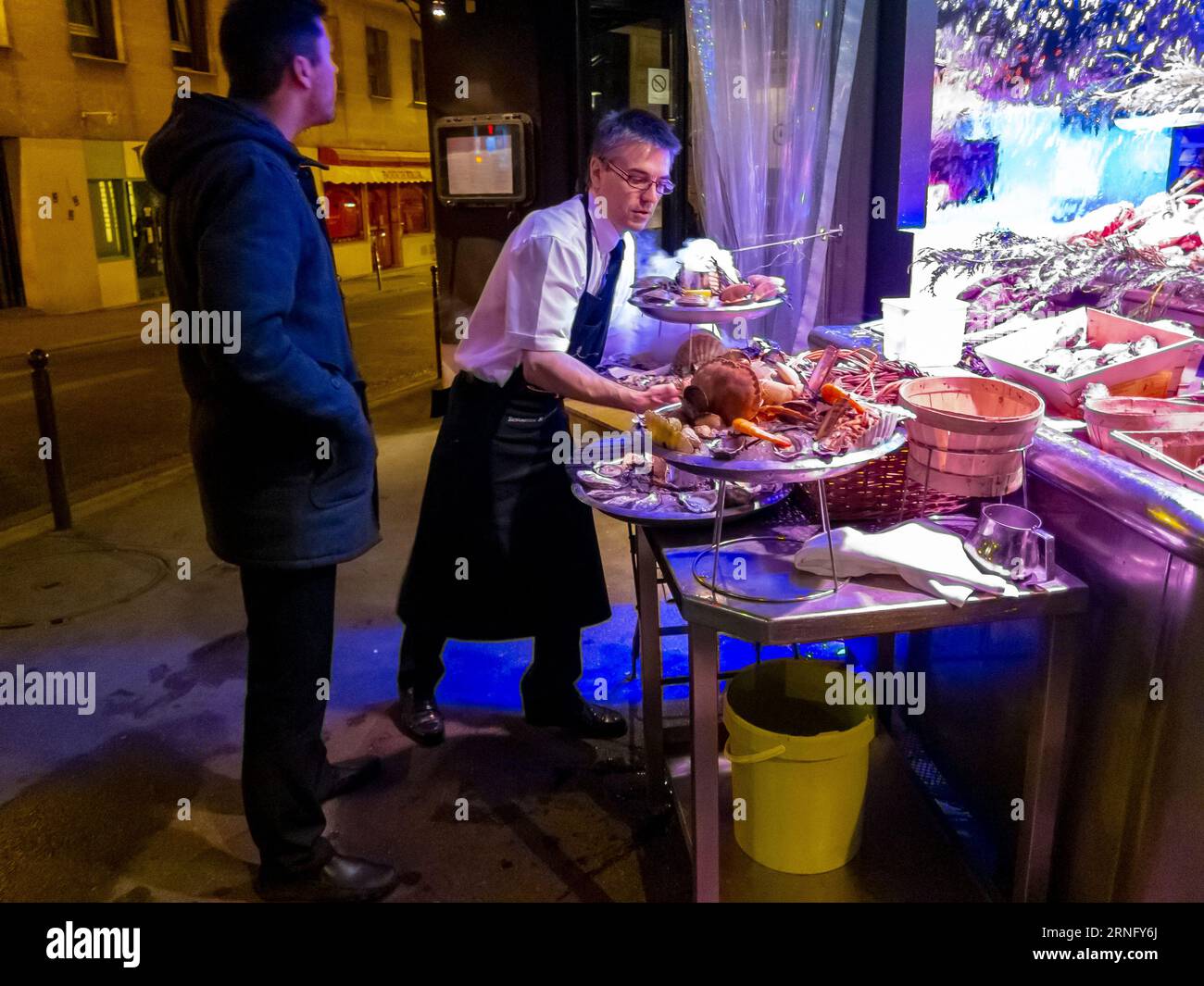 Paris, Frankreich, Kellner, der vor dem traditionellen französischen Bistro-Restaurant arbeitet, Fischtablett-Abend zubereitet, Restaurantarbeiter Stockfoto