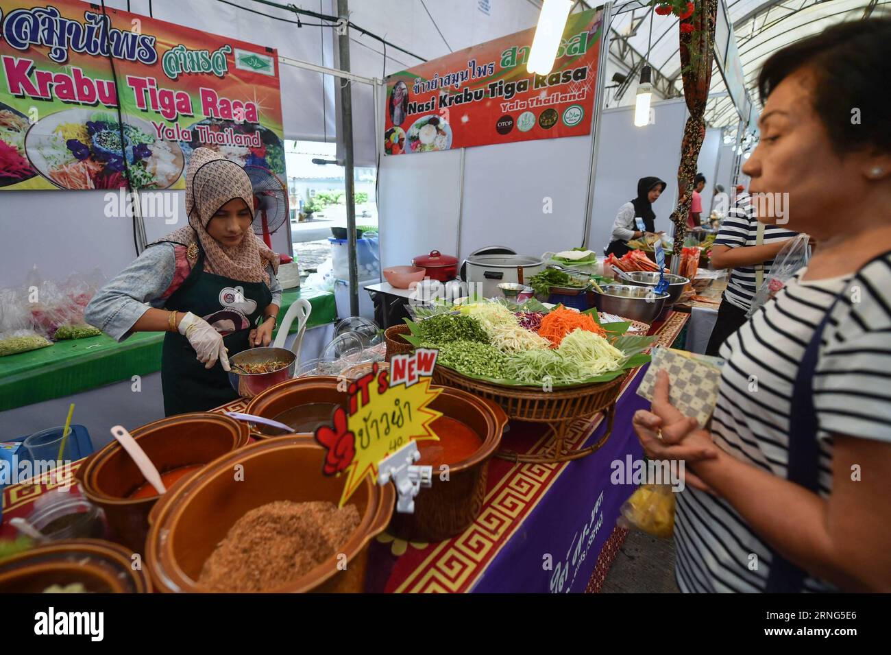 (160906) -- NONTHABURI, 6. September 2016 -- Ein Ladenbesitzer macht Nasi Krabu Tiga Rasa, ein lokales Gericht aus der Provinz Yala in Südthailand, während einer Messe im zentralen thailändischen Nonthaburi am 6. September 2016. In der Nähe von Bangkok findet eine Messe mit Produkten aus Yala, Pattani, Narathiwat und Songkhla statt, die ein Versuch der thailändischen Regierung ist, Produkte aus diesen Provinzen zu fördern, die im letzten Jahrzehnt von Explosionen und Aufständischen heimgesucht wurden. ) (lr) THAILAND-NONTHABURI-SOUTHERN PROVINCES-PRODUCT-TRADE FAIR LixMangmang PUBLICATIONxNOTxINxCHN 160906 Nonthaburi Sept 6 2016 A Shop Owner Makes Stockfoto