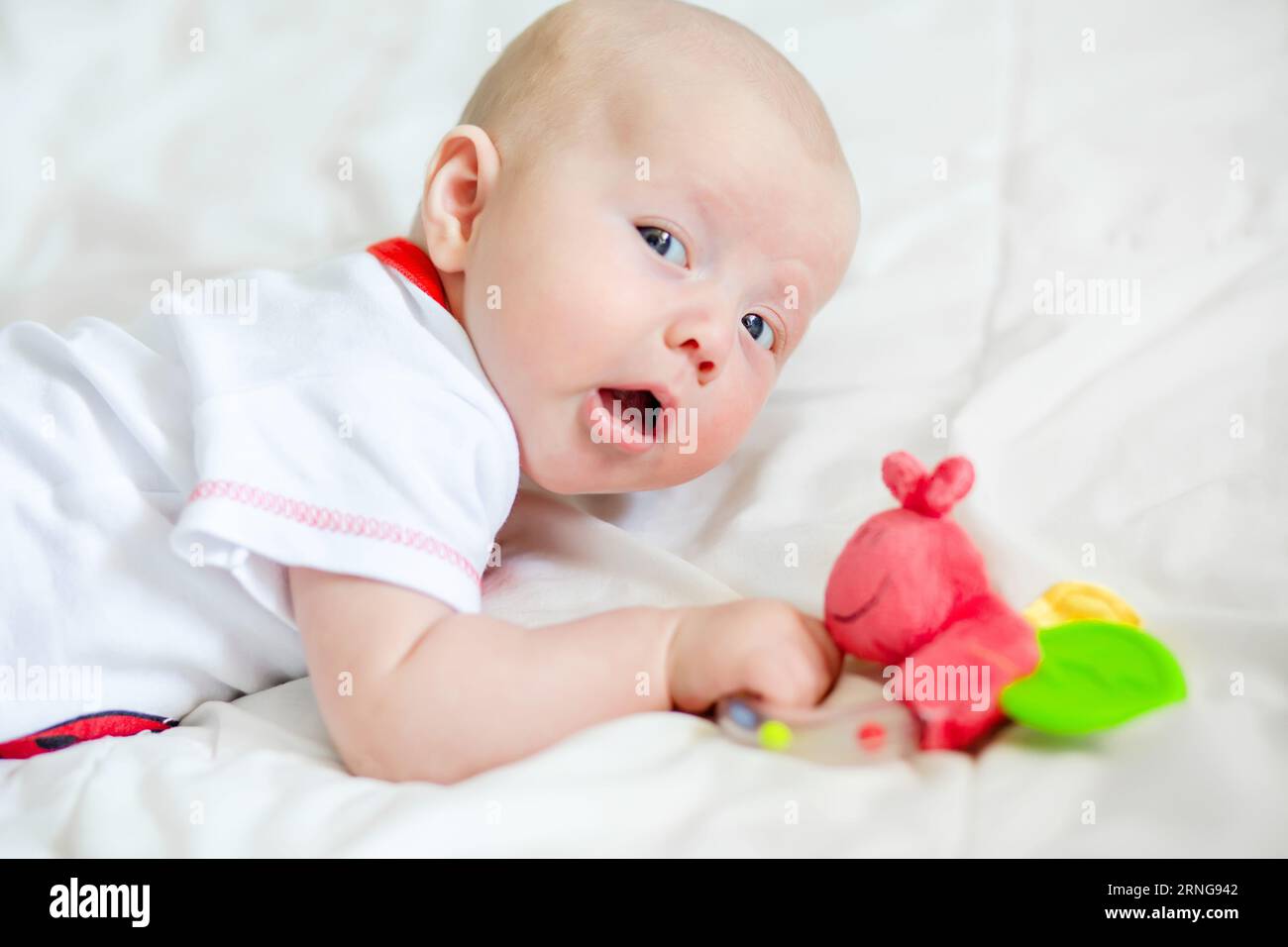 Greifreflex bei einem Neugeborenen. Zeit, die erste Rassel zu kaufen. Baby von 2 Monaten hält den Kopf Stockfoto
