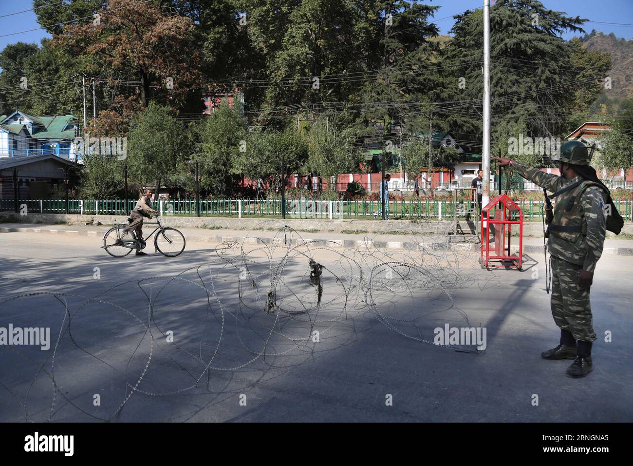 (161007) -- SRINAGAR, 7. Oktober 2016 -- eine indische paramilitärische Truppe hält einen Radfahrer außerhalb des Büros der United Nations Military Observer Group in India and Pakistan (UNMOGIP) während Beschränkungen in Srinagar, Sommerhauptstadt des von Indien kontrollierten Kaschmirs, 7. Oktober 2016. Die Behörden verhängten Beschränkungen in Teilen des von Indien kontrollierten Kaschmirs, um Proteste zu verhindern. )(zcc) KASHMIR-SRINAGAR-RESTRIKTIONEN JavedxDar PUBLICATIONxNOTxINxCHN Srinagar OCT 7 2016 to Indian paramilitary Trooper hält einen Radfahrer vor dem Büro der Militärbeobachtergruppe der Vereinten Nationen in Indien und Pakistan UNMO auf Stockfoto