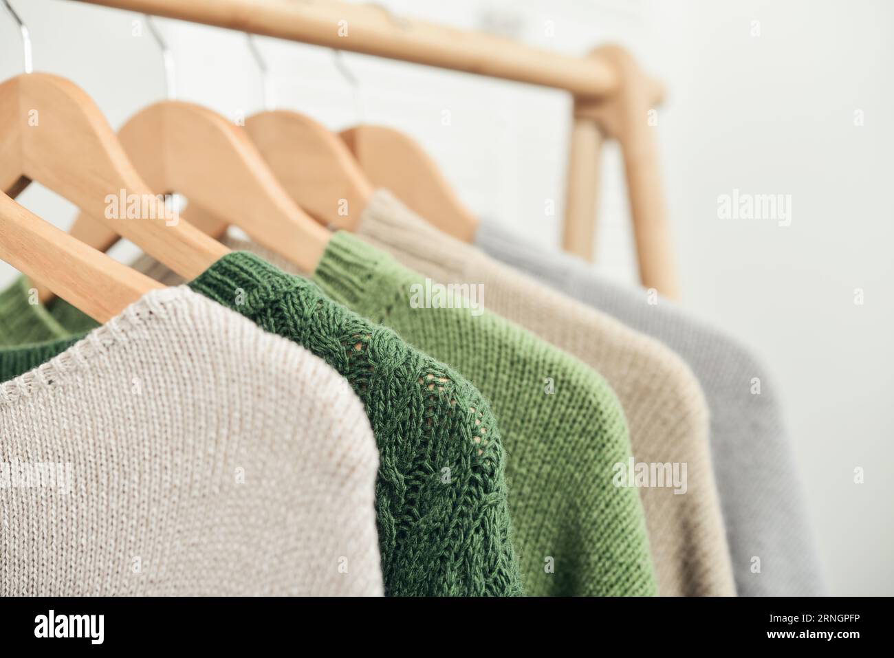 Bunte, handgestrickte Pullover auf Kleiderbügeln in Nahaufnahme. Modekonzept. Stockfoto