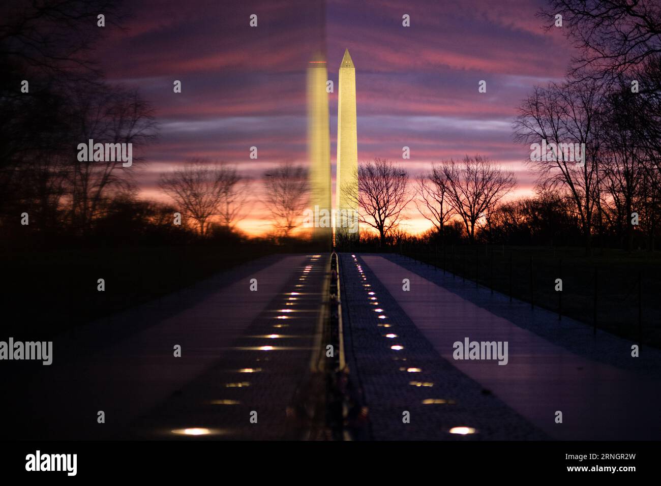 Vietnam Veterans Memorial Washington Monument Washington DC // WASHINGTON DC – das Vietnam Veterans Memorial ist eine ergreifende Hommage an diejenigen, die im Vietnamkrieg gedient haben. Diese Mauer aus schwarzem Granit trägt die Namen von über 58.000 Soldaten, die entweder bei der Aktion getötet wurden oder vermisst bleiben. Das Denkmal dient als Ort der Reflexion und Erinnerung für Veteranen, Familien und Besucher gleichermaßen. In der Ferne befindet sich das Washington Monument. Stockfoto