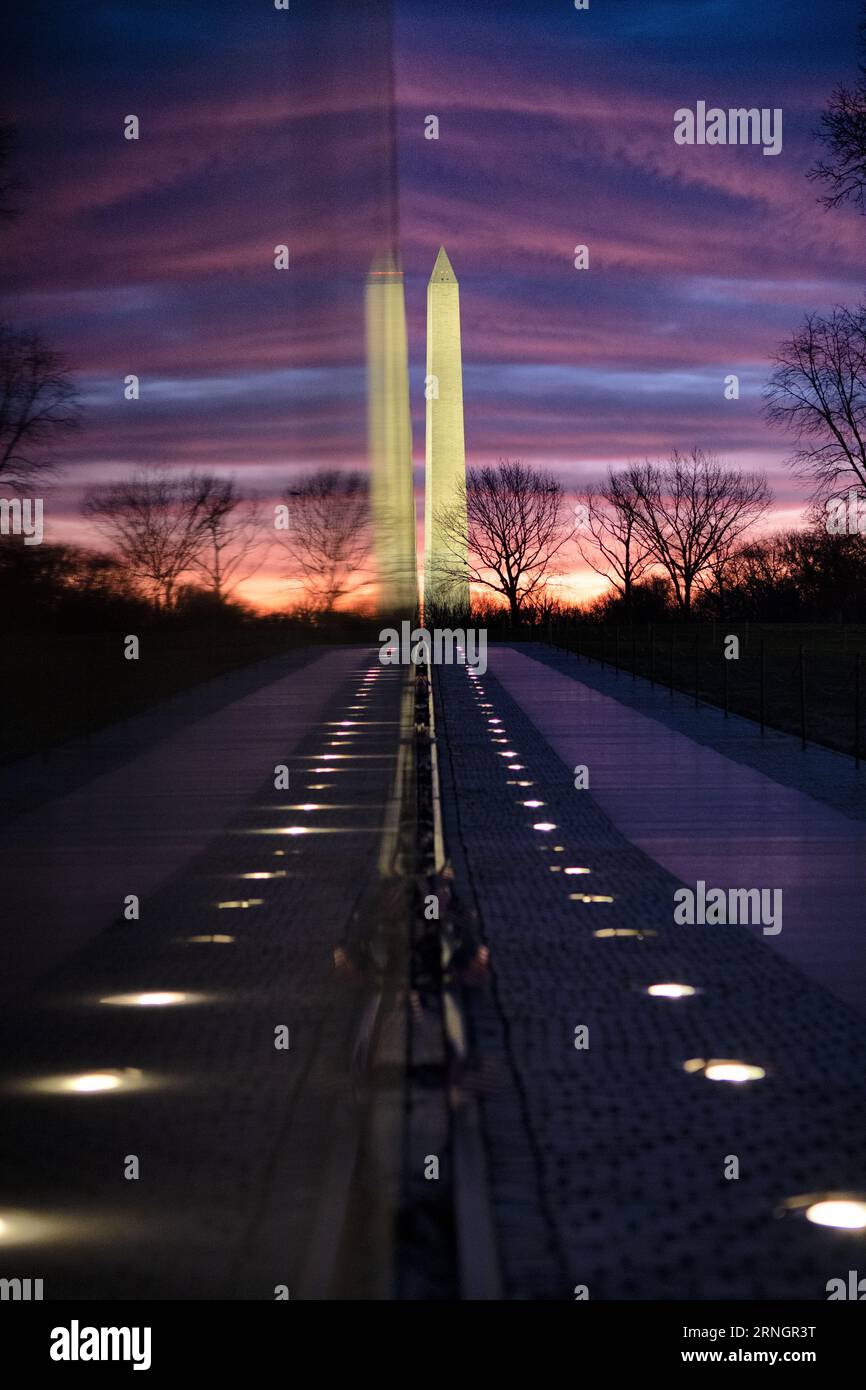 Vietnam Veterans Memorial Washington Monument Reflection Washington DC // WASHINGTON DC – das Vietnam Veterans Memorial ist eine ergreifende Hommage an diejenigen, die im Vietnamkrieg gedient haben. Diese Mauer aus schwarzem Granit trägt die Namen von über 58.000 Soldaten, die entweder bei der Aktion getötet wurden oder vermisst bleiben. Das Denkmal dient als Ort der Reflexion und Erinnerung für Veteranen, Familien und Besucher gleichermaßen. In der Ferne befindet sich das Washington Monument. Stockfoto