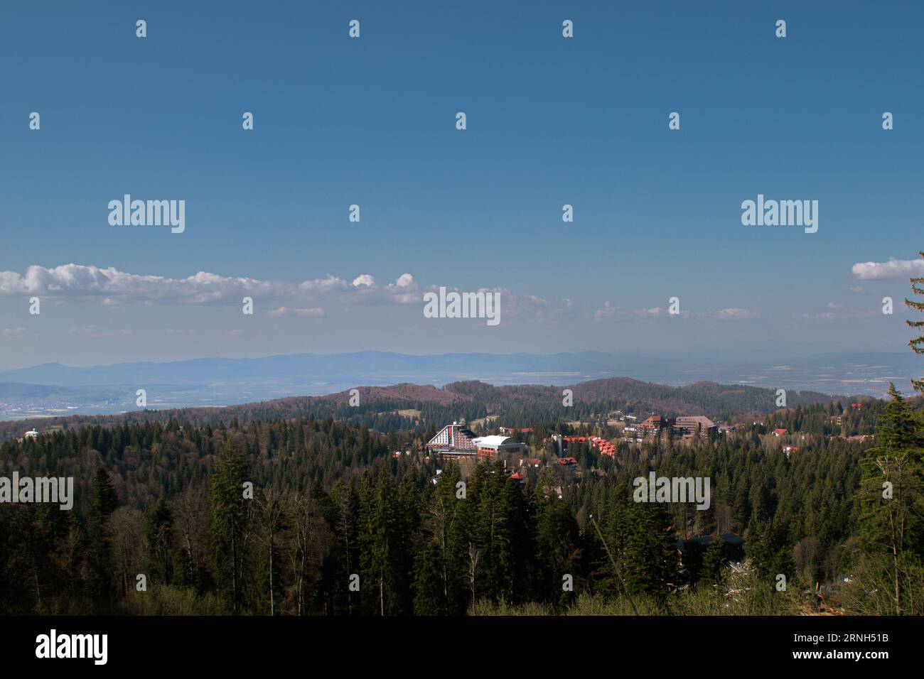 Landschaft von einem hohen Punkt über dem Wald und den Gebäuden von Poiana Brasov Rumänien im Frühjahr gesehen. Stockfoto