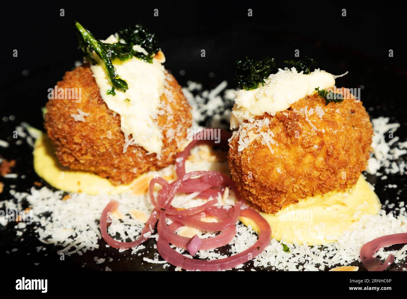 Arancini-Bälle werden in Valletta, Malta serviert. Sie sind eines der vielen beliebten Gerichte in Malta, die von der italienischen und speziell sizilianischen Küche beeinflusst werden. Stockfoto