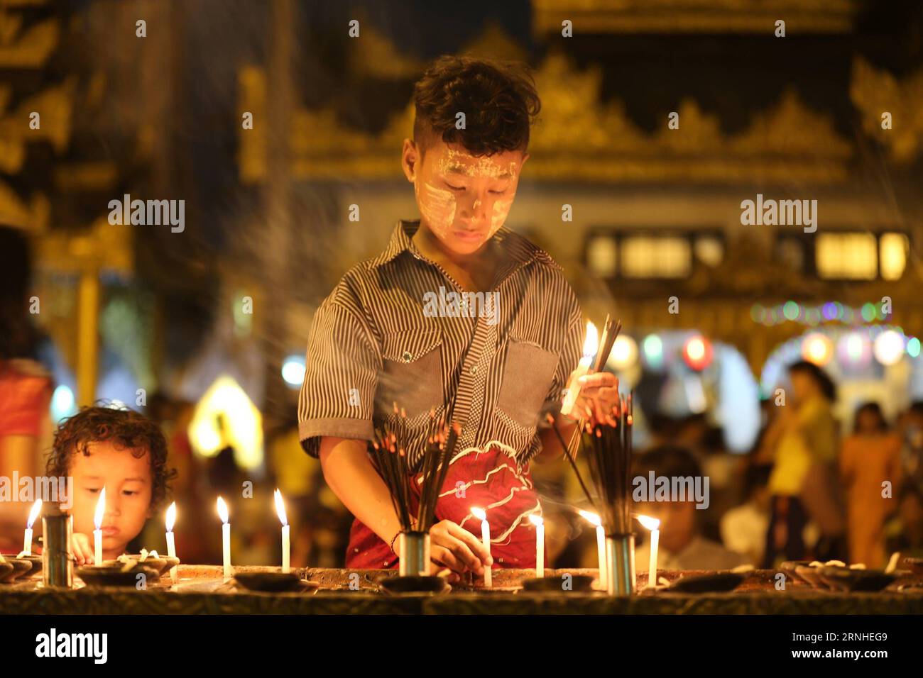 Ein Junge zündet Kerzen auf Myanmars traditionellem Tazaungdaing-Festival in der Shwedagon-Pagode in Yangon, Myanmar, 13. November 2016 an. Das Tazaungdaing Festival, auch bekannt als das Festival der Lichter, das im achten Monat des traditionellen myanmarischen Kalenders auf den Vollmondtag fällt, wird als Nationalfeiertag in Myanmar gefeiert und markiert das Ende der Regenzeit. ) (zw) MYANMAR-YANGON-TAZAUNGDAING FESTIVAL UxAung PUBLICATIONxNOTxINxCHN A Boy Lights Candles ON Myanmar S Traditional Tazaungdaing Festival in der Shwedagon Pagoda in Yangon Myanmar 13. November 2016 das Tazaungdaing Festival so k Stockfoto