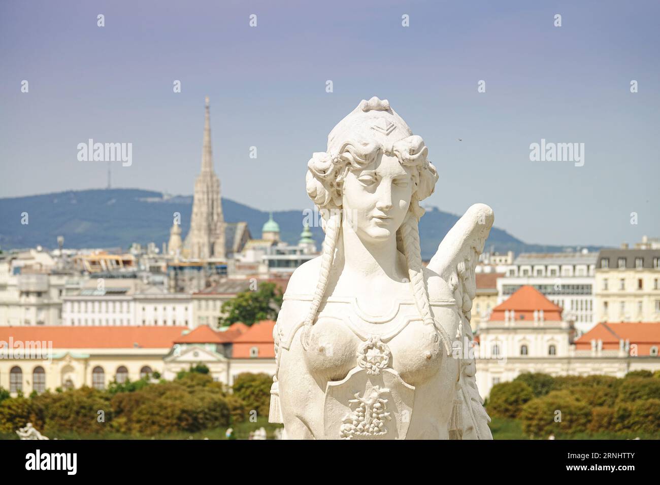 Wien, Österreich, August 27 2023, Skulptur der Sphinx mit St. Stephansdom im Hintergrund. Das Belvedere ist ein prachtvoller Barockpalast W Stockfoto