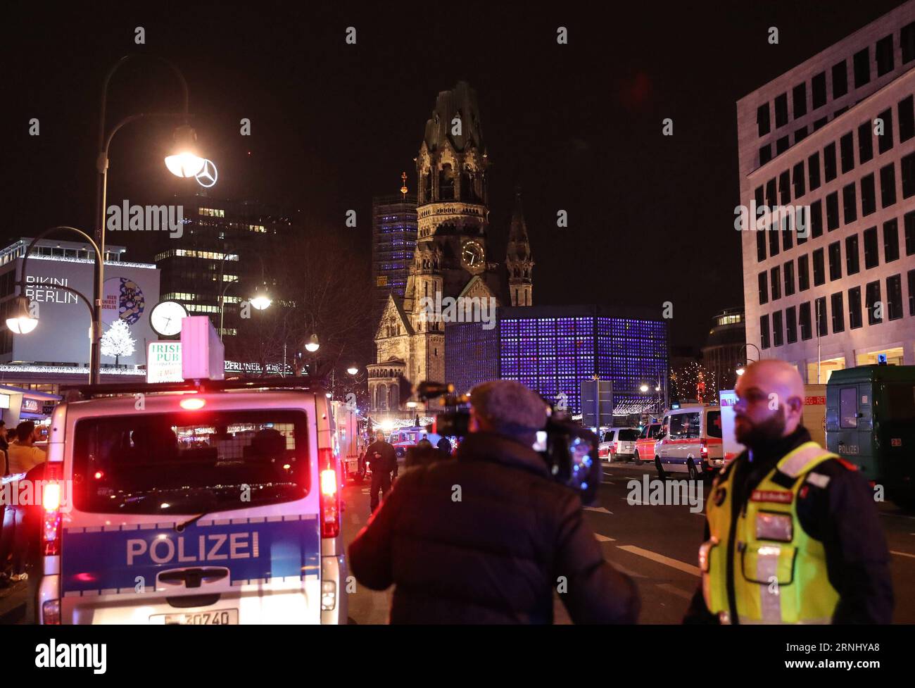 Lkw rast in Weihnachtsmarkt am Breitscheidplatz in Berlin (161219) -- BERLIN, 19. Dezember 2016 -- Sicherheitspersonal und eine Jornalistin arbeiten in der Nähe eines LKW-Absturzes auf einem Weihnachtsmarkt in Berlin, 19. Dezember 2016. Ein Lastwagen, der am Montagabend auf einem Weihnachtsmarkt in Berlin in die Menge pflügte, neun Menschen tötete und viele andere verletzte, gab die Berliner Polizei über Twitter bekannt. DEUTSCHLAND-BERLIN-LKW-UNFALL ShanxYuqi PUBLICATIONxNOTxINxCHN Lkw ruhen auf dem Weihnachtsmarkt bei den Verwaltungen in Berlin DEC 19 2016 Sicherheitspersonal und eine Jornalisten-Arbeit in der Nähe des Standorts einer LKW-CRAs Stockfoto