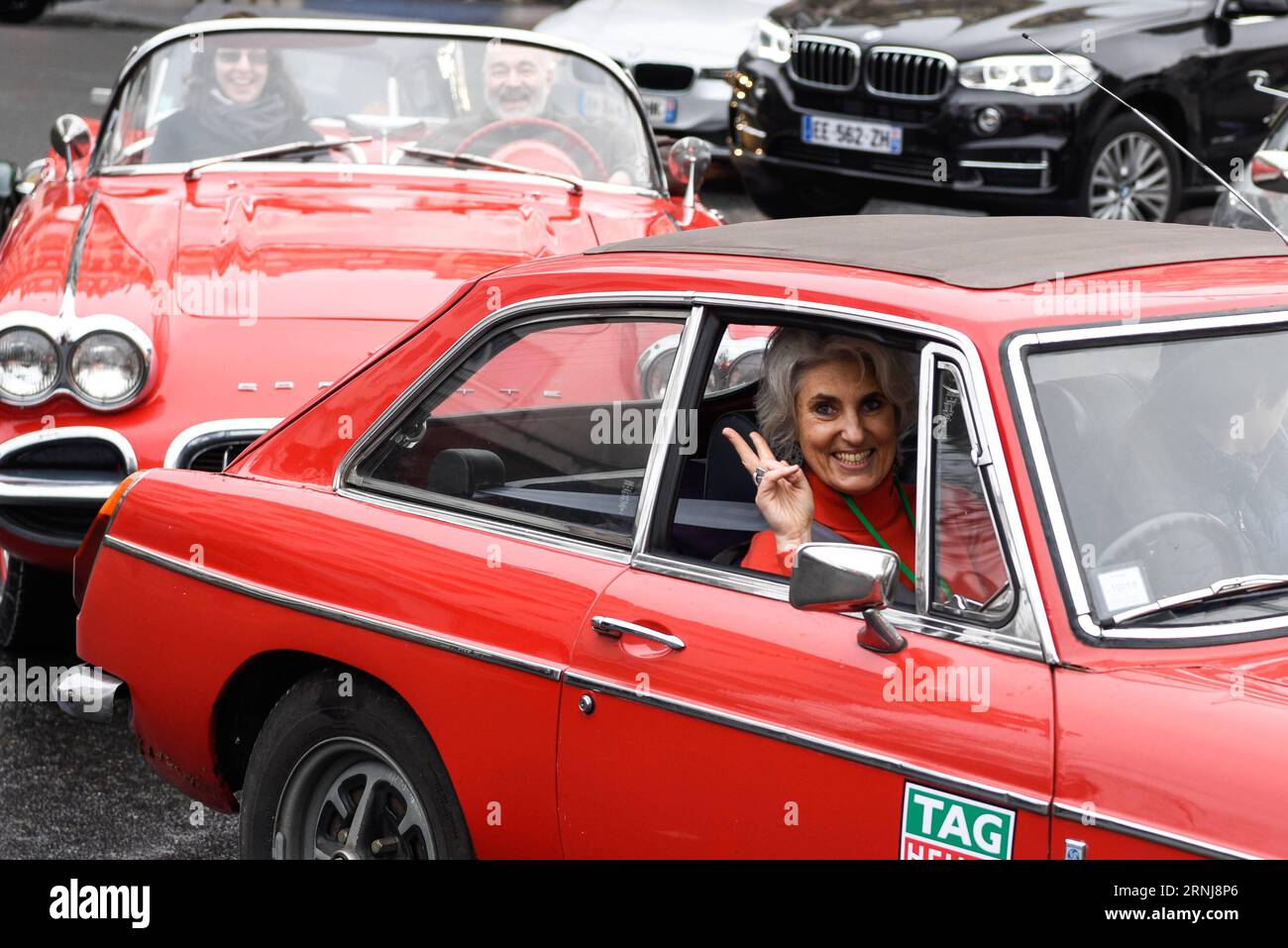 (170108) -- PARIS, 8. Januar 2017 -- Eine Frau zeigt während der 17. Pariser Kreuzung der klassischen Autos in Paris, Frankreich, am 8. Januar 2017. Mehr als siebenhundert Oldtimer, Motorräder und Fahrräder nahmen am Sonntag an der 17. Pariser Kreuzung der Oldtimer Teil. ) (lrz) FRANKREICH-PARIS-17th PARIS CROSSING OF OLDTIMER ChenxYichen PUBLICATIONxNOTxINxCHN Paris 8. Januar 2017 eine Frauengeste während der 17. Paris Crossing of Classic Cars in Paris Frankreich AM 8. Januar 2017 nahmen mehr als sieben hundert Oldtimer Motorräder und Fahrräder AM Sonntag AM 17. Paris Crossing of Classic Teil Cars lrz Franc Stockfoto