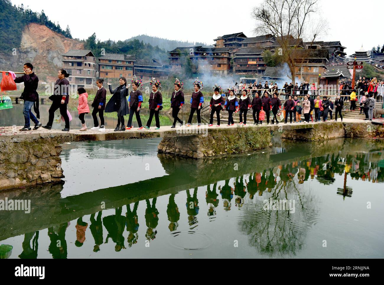 (170130) -- LIUZHOU, 30. Januar 2017 -- Eine Prozession von Menschen, die Körbe mit Neujahrsgeschenken tragen, begleitet eine Braut auf dem Weg zu ihrer Mutter nach Hause im Dorf Chengyang des autonomen Bezirks Sanjiang Dong in Liuzhou, südchinesische autonome Region Guangxi Zhuang, 30. Januar 2017. Es ist eine lokale ewige Tradition, am zweiten Tag des Neujahrsmondes eine Hochzeitsfeier abzuhalten und dann die Bräute am dritten Tag zurück zu ihrer Mutter nach Hause zu begleiten )(wyo) CHINA-GUANGXI-DONG ETHNISCHE GRUPPENTRADITION (CN) GongxPukang PUBLICATIONxNOTxINxCHN Liuzhou Jan 30 2017 eine Prozession von Prominenten, die Baskets of New Year GI tragen Stockfoto