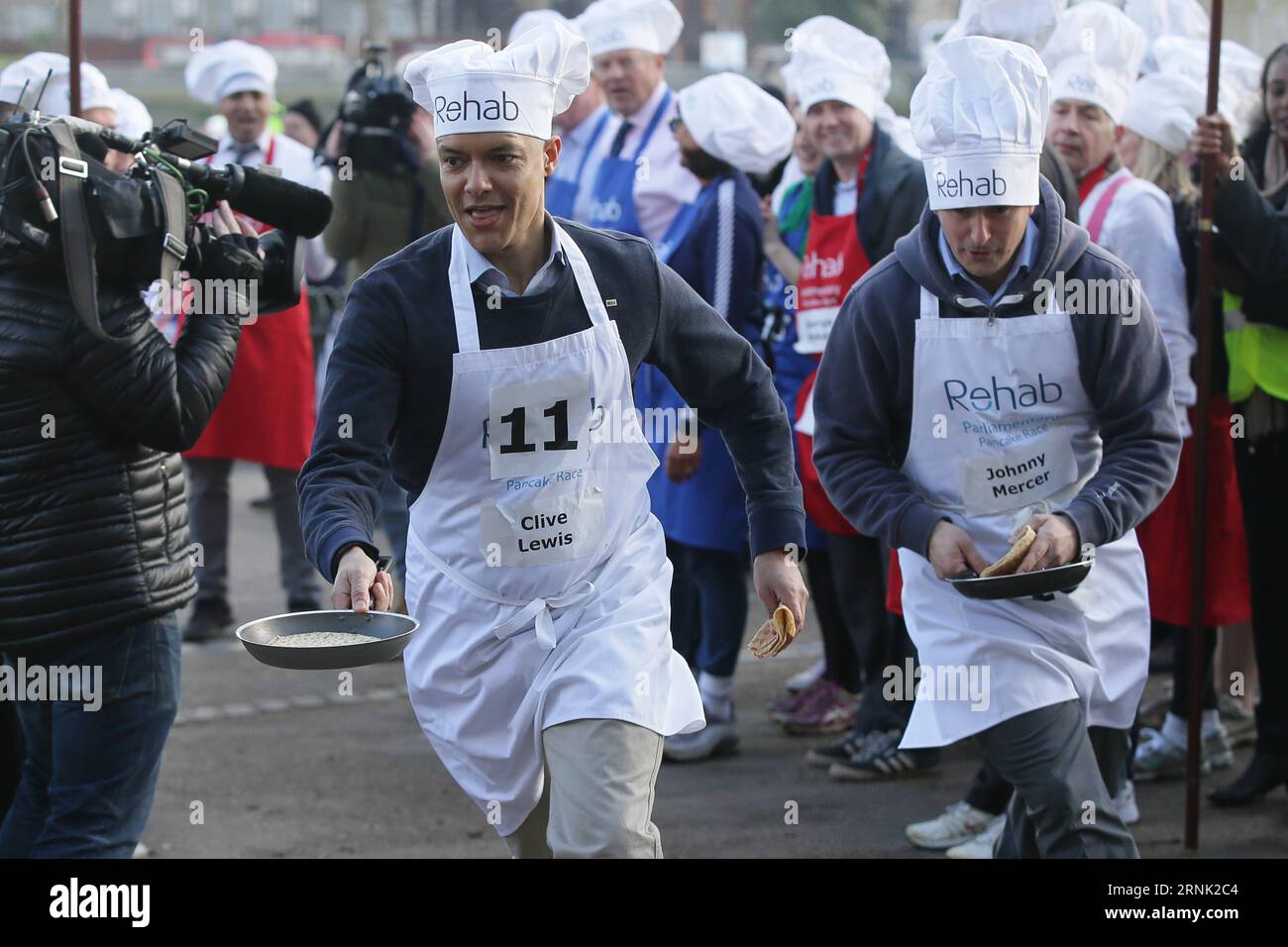 (170228) -- LONDON, 28. Februar 2017 -- die Abgeordneten Clive Lewis (L) und Johnny Mercer nehmen am 28. Februar 2017 am Rehab Parliamentary Pancake Race in den Victoria Tower Gardens in London Teil. Das jährliche Rennen am Shrove Tuesday ist eine Staffel zwischen Parlamentsabgeordneten, Lords und den Medien und sammelt Geld für die Rehab-Behindertenorganisation. ) (zy) GROSSBRITANNIEN-LONDON-PARLAMENT-PFANNKUCHENRENNEN TimxIreland PUBLICATIONxNOTxINxCHN London Feb 28 2017 MPS Clive Lewis l und Johnny Mercer nehmen AM Rehab Parliamentary Pancake Race in Victoria Tower Gardens in London Großbritannien AM 28 2017. Februar AM Annual Race Hero ON Shrov Teil Stockfoto