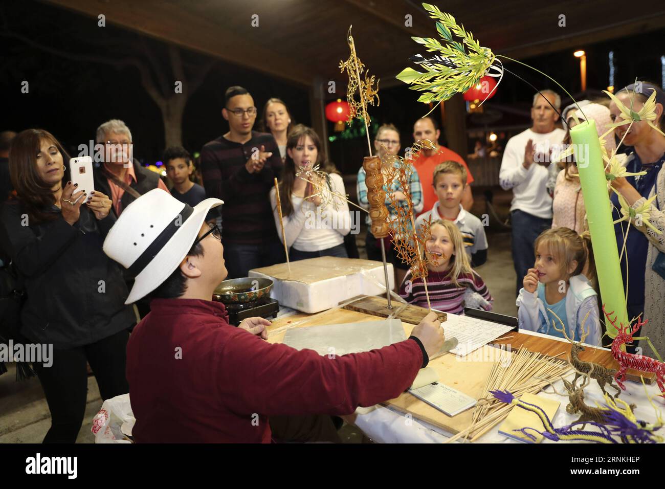 (170402) -- BOCA RATON, 2. April 2017 -- Li Jun, ein chinesischer Zuckerzeichner, übergibt einem Kind während eines Laternenfestes im Sunset Cove Amphitheater in Boca Raton, Florida, USA, am 24. März 2017 eine Zuckerzeichnung. Sugar Drawing, eine traditionelle chinesische Volkskunst, die heißes Karamell verwendet, um zweidimensionale Figuren zu kreieren, gehört zu den vielen Volkskunst, die vom 24. Februar bis 9. April beim Chinese Lantern Festival im Palm Beach County, einem Paradies für Urlauber in Südflorida, ausgestellt wird. ) (zy) U.S.-BOCA RATON-CHINESE FOLK ARTS WangxYing PUBLICATIONxNOTxINxCHN Boca Raton 2. April 2017 lef Stockfoto