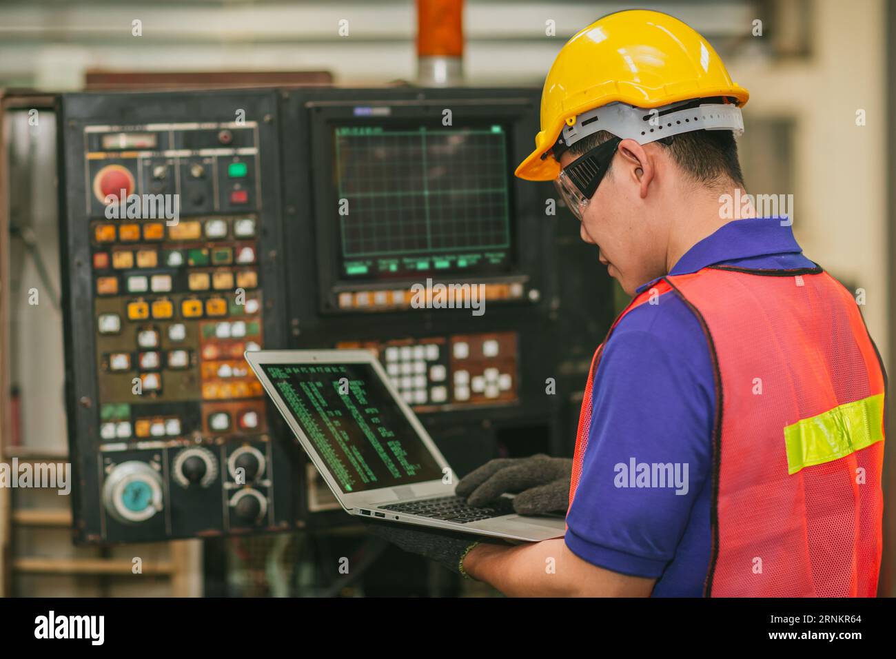 Smart Engineer Programmierer Service Panel Programm bedienen CNC-Drehmaschine mit Laptop Computer Reparatur alte Maschine. Stockfoto