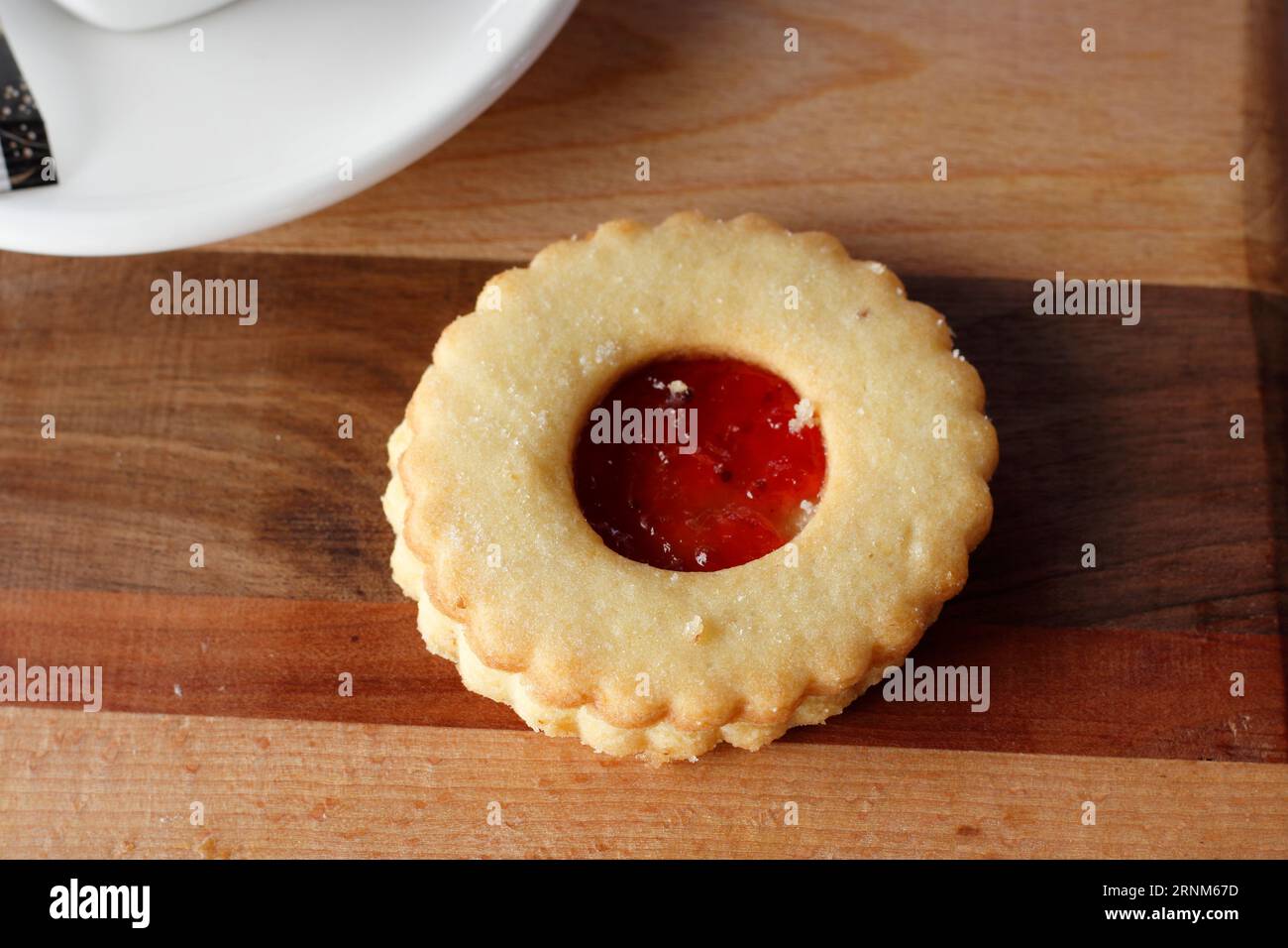 Traditioneller Linzer Weihnachtskeks (Linecke pecivo) gefüllt mit Erdbeermarmelade auf Holzbrett Stockfoto