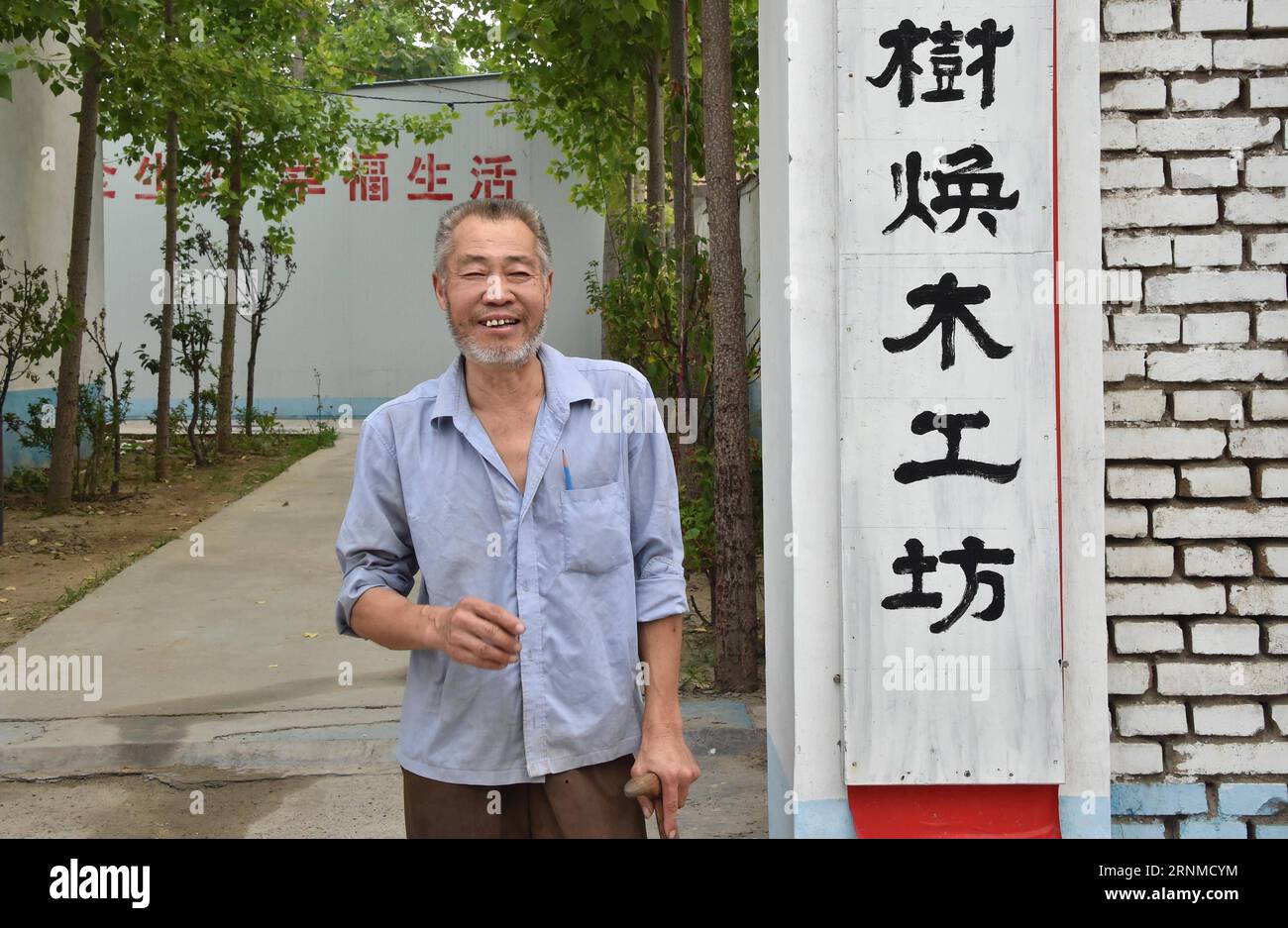 (170523) -- JINAN, 23. Mai 2017 -- Zhao Shuhuan steht am Tor seiner Werkstatt im Dorf Dongtai der Gemeinde Zhutai in Zibo, ostchinesische Provinz Shandong, 22. Mai 2017. Der 54-jährige Zhao hat seit seiner Kindheit eine Beinbehinderung. Als Zhao älter wurde und die Nachfrage nach Tischlerei zurückging, geriet er in die Armut. Vor zwei Jahren half die örtliche Armutsbekämpfungsabteilung Zhao, eine Werkstatt zu bauen und Schneid- und Poliermaschinen als eine gezielte Maßnahme in Armutsbekämpfungskampagnen zu kaufen. Es fand auch einen Stand auf einem Möbelmarkt für ihn. Verkaufsvolumen der Tischlerei von Zhao Stockfoto