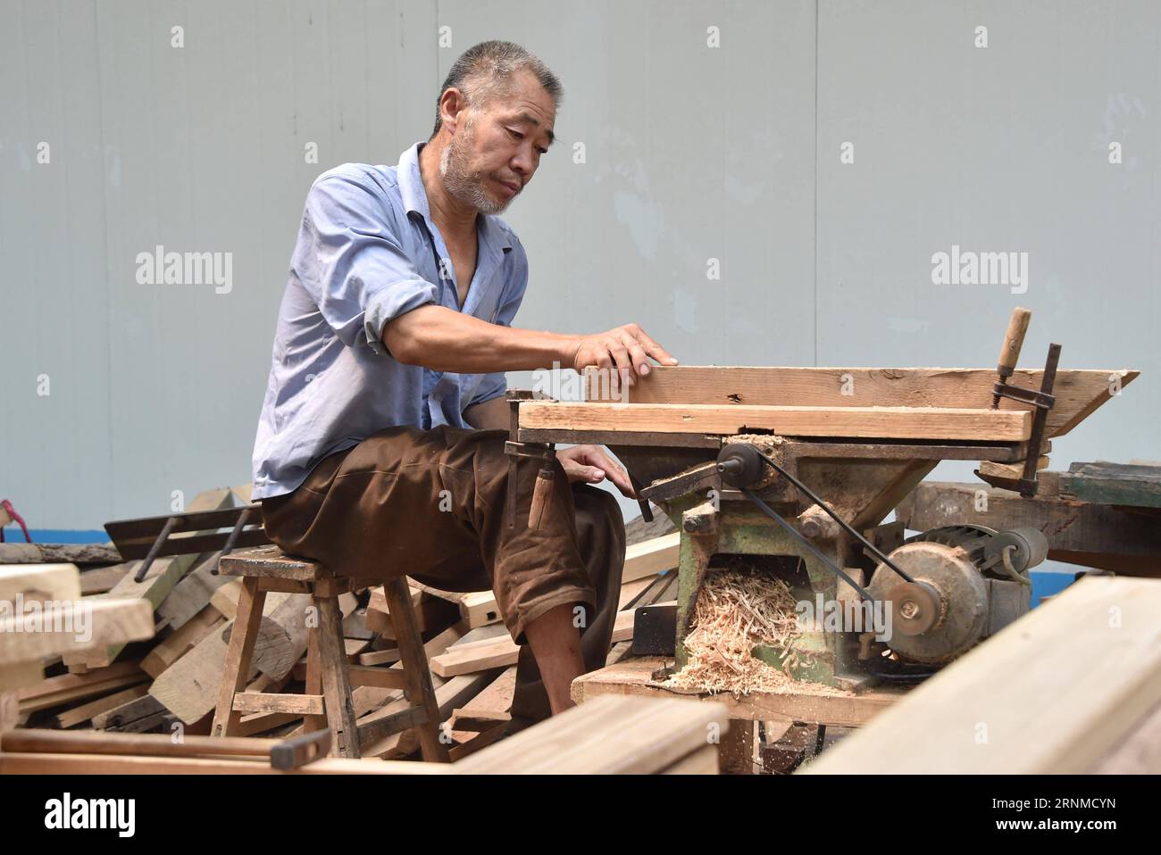 (170523) -- JINAN, 23. Mai 2017 -- Zhao Shuhuan verarbeitet Materialien in seiner Werkstatt im Dorf Dongtai der Gemeinde Zhutai in Zibo, ostchinesische Provinz Shandong, 22. Mai 2017. Der 54-jährige Zhao hat seit seiner Kindheit eine Beinbehinderung. Als Zhao älter wurde und die Nachfrage nach Tischlerei zurückging, geriet er in die Armut. Vor zwei Jahren half die örtliche Armutsbekämpfungsabteilung Zhao, eine Werkstatt zu bauen und Schneid- und Poliermaschinen als eine gezielte Maßnahme in Armutsbekämpfungskampagnen zu kaufen. Es fand auch einen Stand auf einem Möbelmarkt für ihn. Verkaufsvolumen der Tischlerei von Zhao Stockfoto