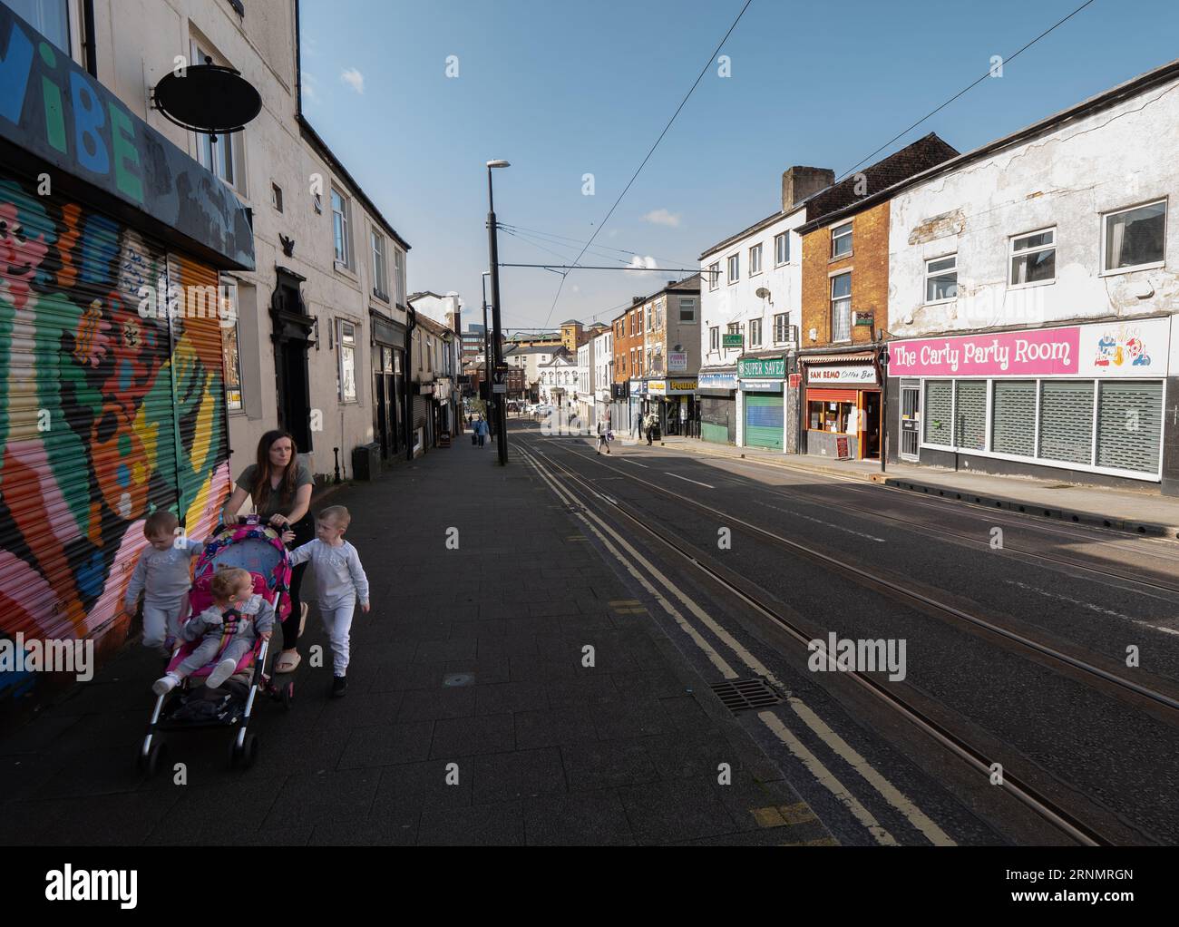 Lady schiebt Kinderwagen mit Kindern an verschlossenen Geschäften in der Drake Street vorbei. Rochdale. Stadtbezirk Greater Manchester. UK.Picture: Garyroberts/World WideFeature Stockfoto