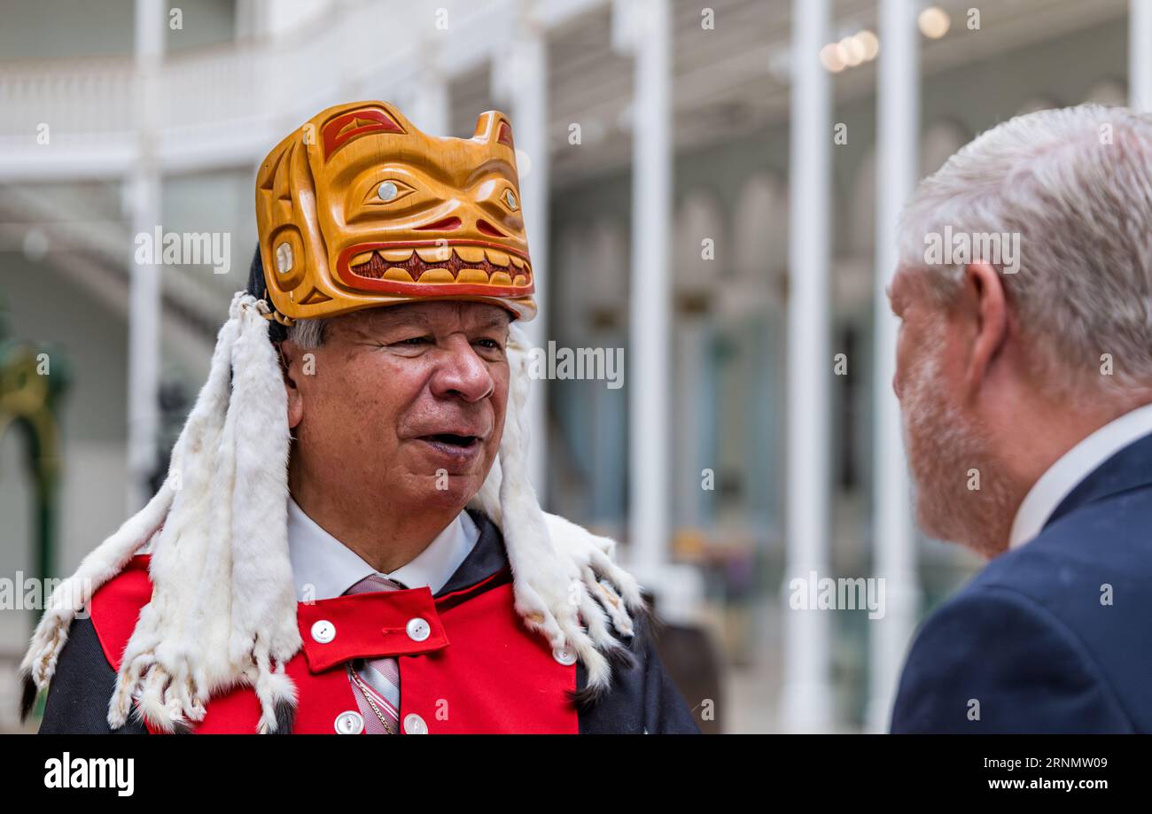 Nisga'a, Mitglied der Delegation der ersten Nation, Chief Duuk, spricht mit Angus Robertson (MSP), Kulturminister, National Museum of Scotland, Edinburgh, Vereinigtes Königreich Stockfoto