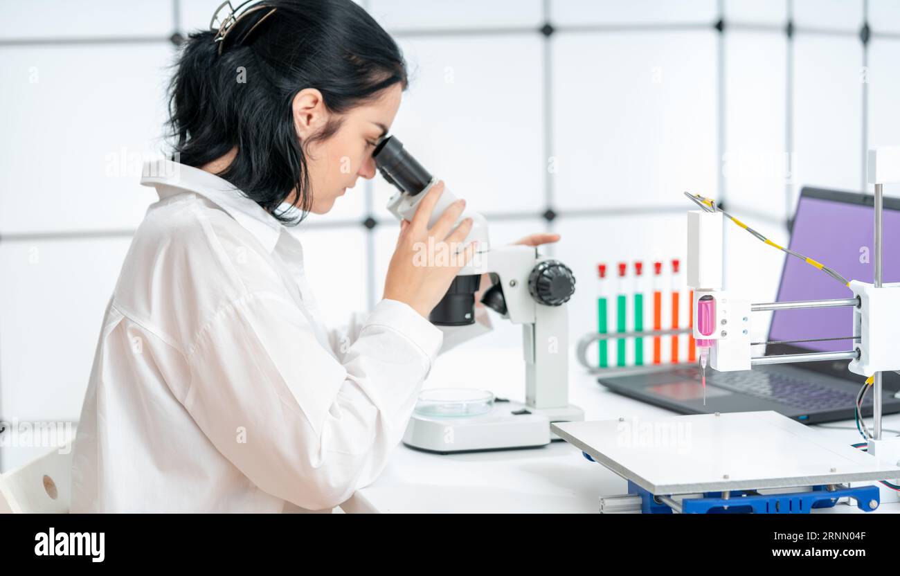 Schülerin im Labor der 3D-Bioprintarbeit mit einer Biochip-Probe Stockfoto