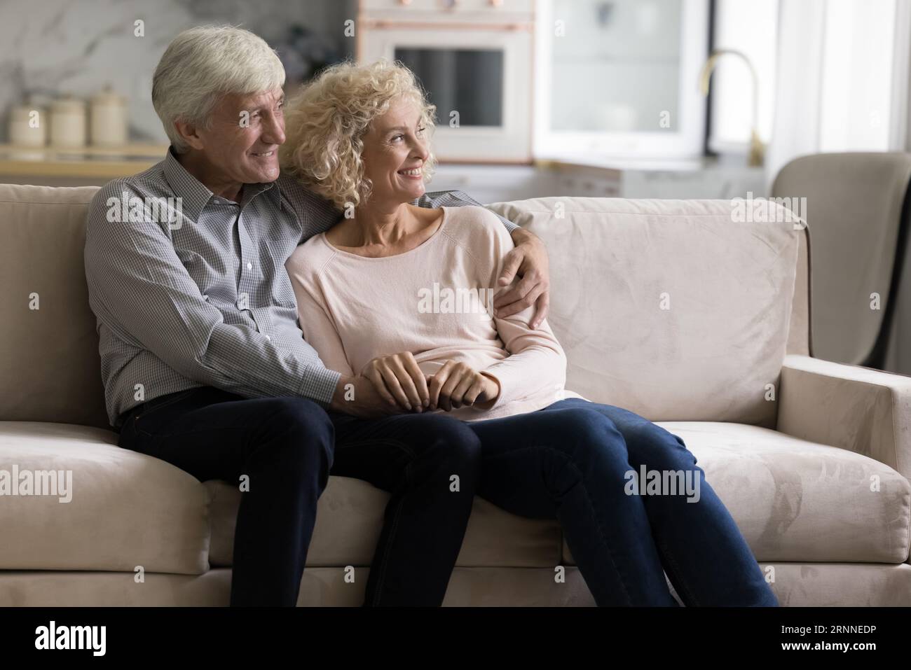 Glückliches reifes, pensioniertes Ehepaar, das zusammen auf dem Sofa ruht Stockfoto