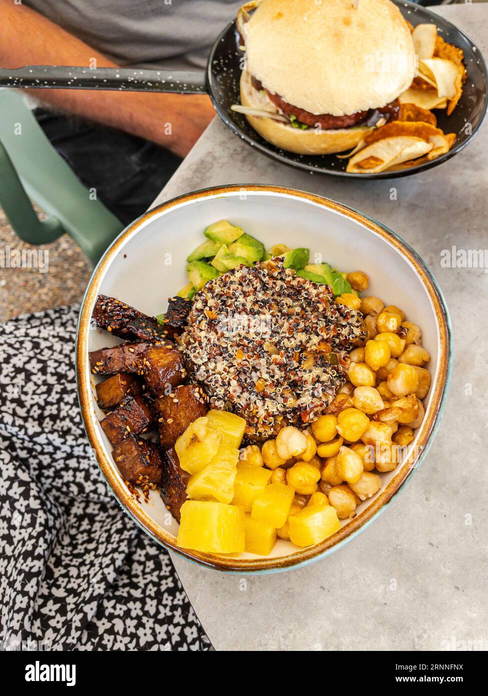 Vegane Quinoa-Poke-Schüssel. Dreifarbige Quinoa, gebraten mit Gemüse, dazu Ananas, Avocado, Kichererbsen und Seitan in Teriyaki-Sauce. Stockfoto