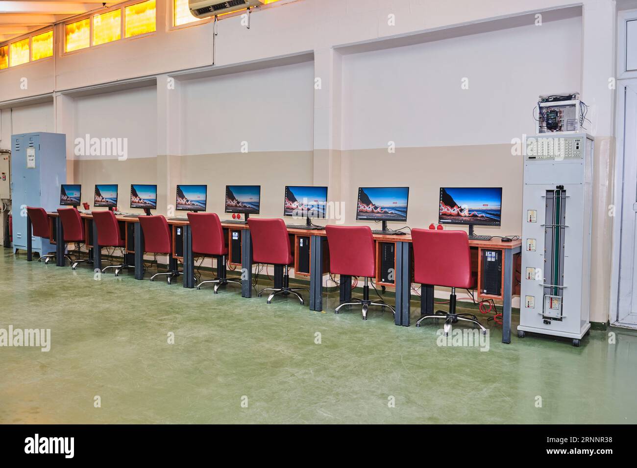 Leeres Computerlabor an einer Universität. Computerraum. Zimmer mit vielen Computern, Schreibtischen, Stühlen und Tastaturen. Rote Sitze. Stockfoto