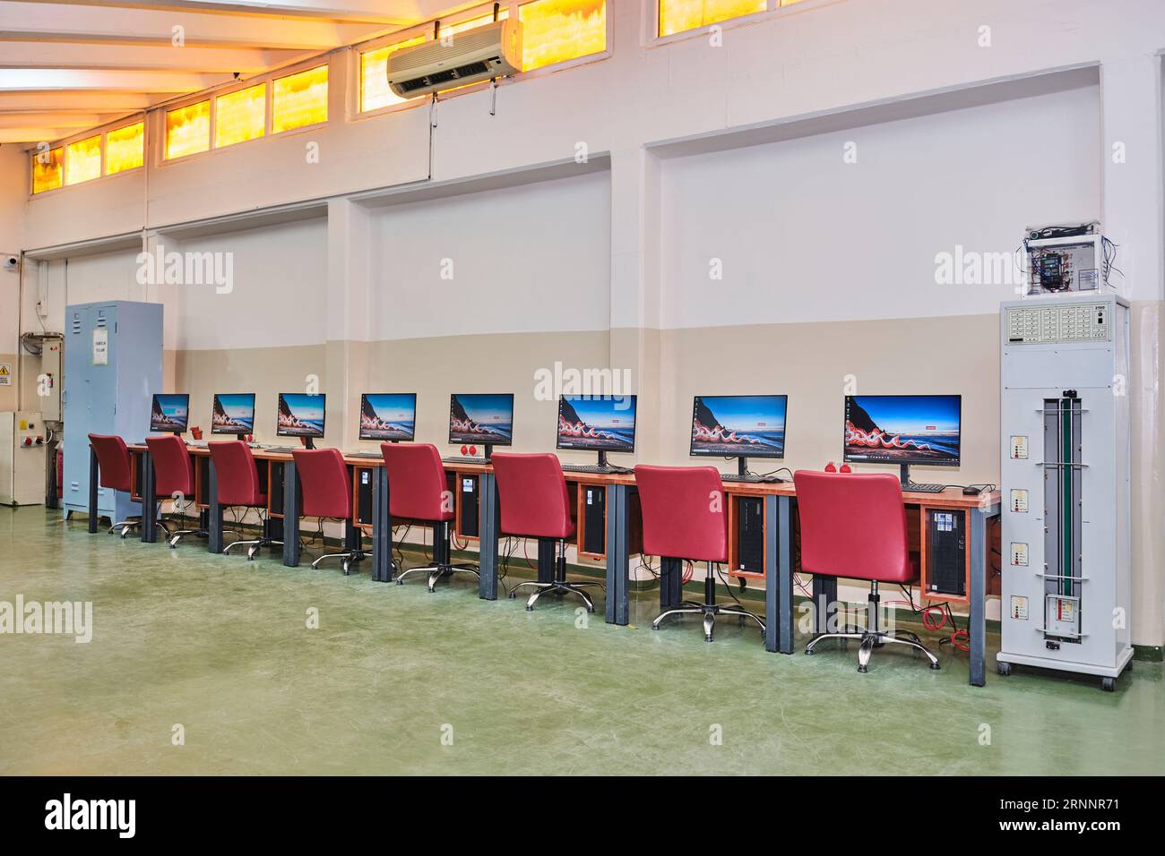 Leeres Computerlabor an einer Universität. Computerraum. Zimmer mit vielen Computern, Schreibtischen, Stühlen und Tastaturen. Rote Sitze. Stockfoto