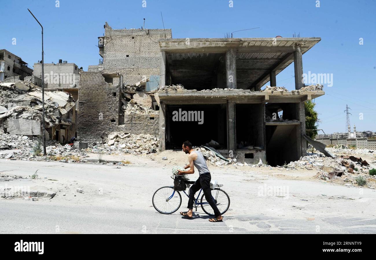 (170729) -- ALEPPO (SYRIEN), 29. Juli 2017 -- Ein Mann schleppt sein Fahrrad im zerschmetterten Ansari-Viertel, östlich von Aleppo, Nordsyrien, 28. Juli 2017. Die Rebellen blieben fünf Jahre im Osten Aleppos, bevor sie im Dezember 2016 evakuierten. Sieben Monate nachdem die syrische Armee die volle Kontrolle über die Stadt übernommen hatte, beginnt das Leben durch Zerstörung und Zerstörung in der Gegend wieder zu schlagen. (Zjy) SYRIEN-ALEPPO-FEATURE AmmarxSafarjalani PUBLICATIONxNOTxINxCHN Aleppo Syrien Juli 29 2017 ein Mann schleppt sein FAHRRAD im zerschmetterten Ansari-Viertel östlich von Aleppo City im Norden Syriens Ju Stockfoto