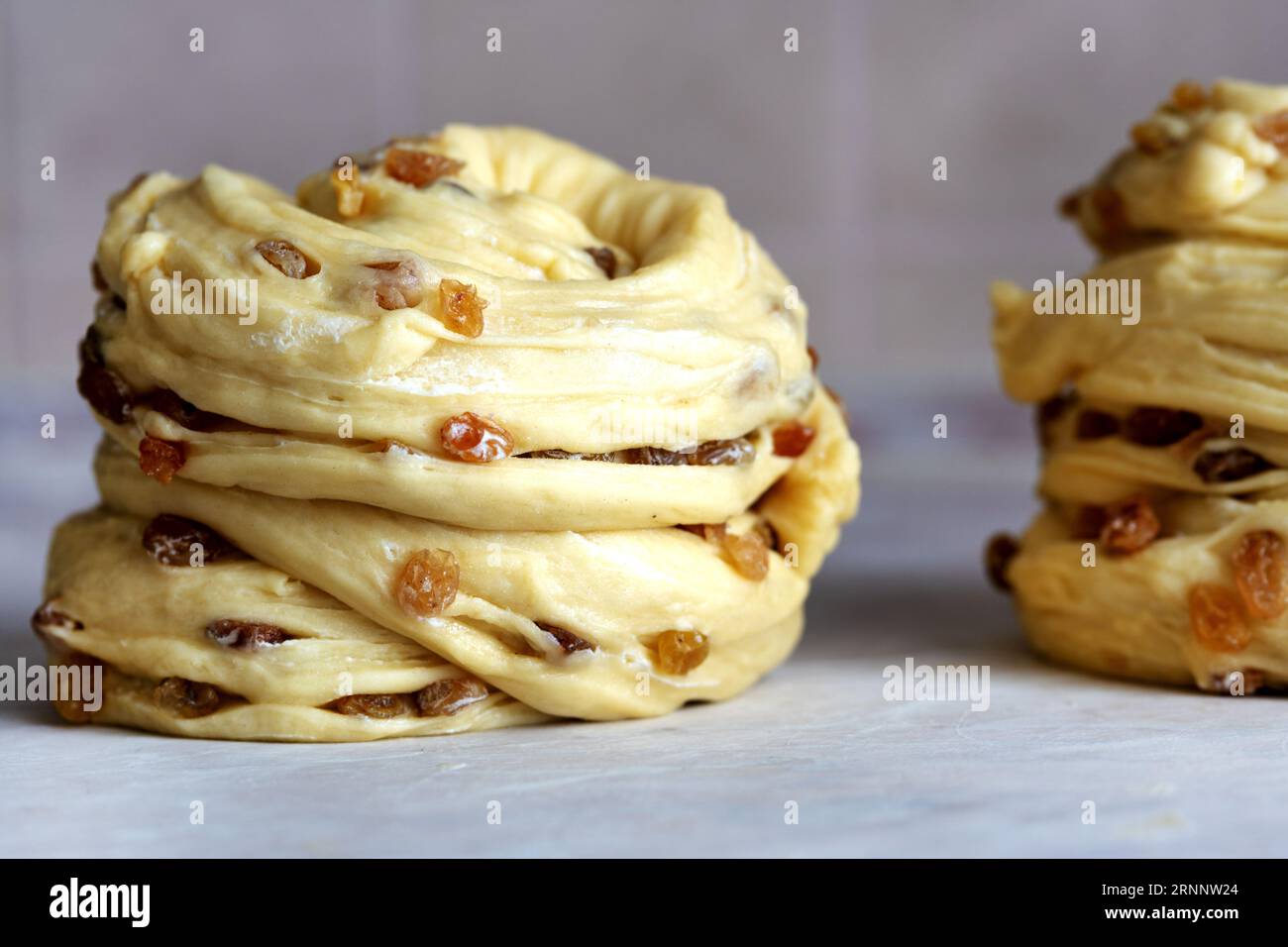Teig mit Rosinen. Craffin vor dem Backen. Hausgemachte Oster-Kruffins. Nahaufnahme Stockfoto